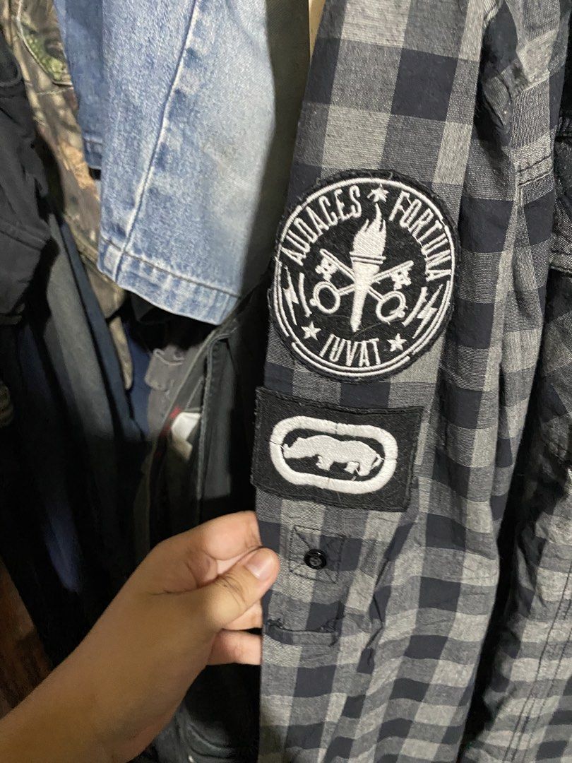 Ecko Unltd Black Grey Plaid Flannel Shirt Patchwork (Category: Tshirts & Polo Shirts ) located in Imus. Submitted by frootiloots4103 (Listing ID 1467153109, Image 3). Description: - Brand: Ecko Unltd - Style: Plaid flannel button-down shirt - Colorway: Black and grey check - 26x28 - Material: 100% cotton, made in India - Details: Dual chest pockets, embroidered skull and American flag patches on sleeves - Condition: Solid streetwear piece loaded 