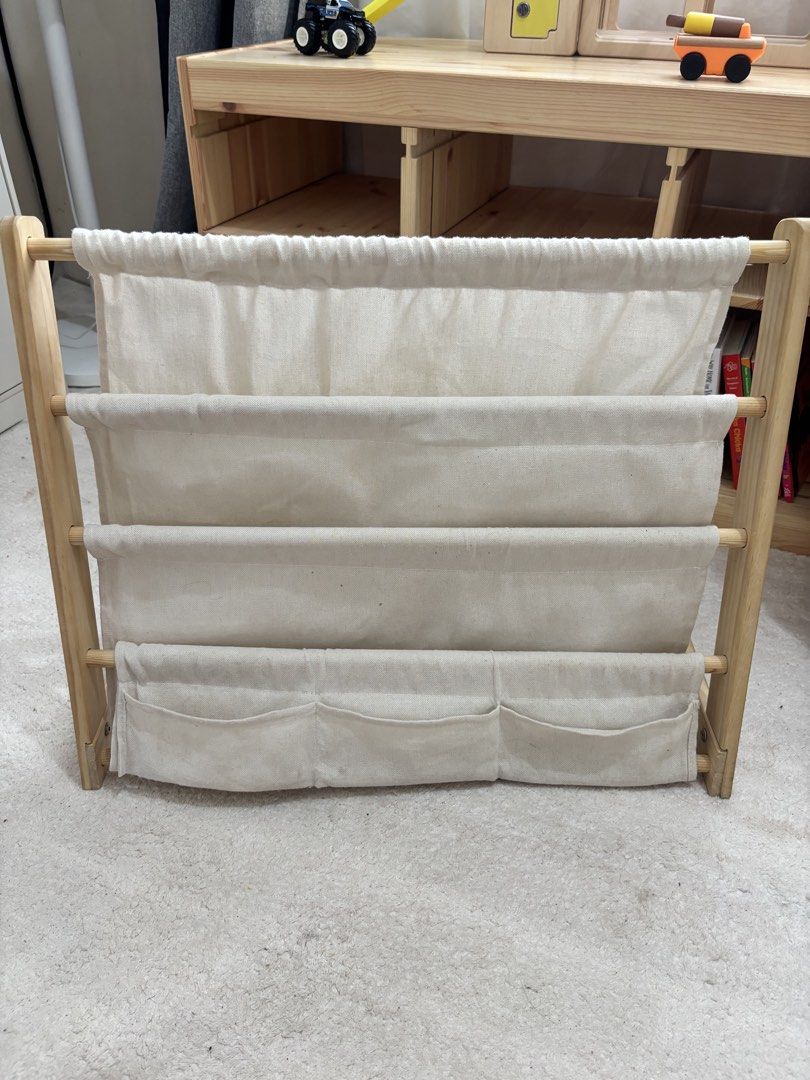 Educrate Multi Layer Montessori Sling Bookshelf (Category: Other Kids Furniture) located in Manila. Submitted by sugarcervantes (Listing ID 1466997249, Image 1). Description: - Brand: Educrate - Material: Natural wood frame with cream canvas fabric pockets - Storage: 4 spacious tiers for picture books + 3 extra small front pockets for toys and small items - Design: Sturdy, floor-standing A-frame - Perfect for: Organizing a child's reading nook or