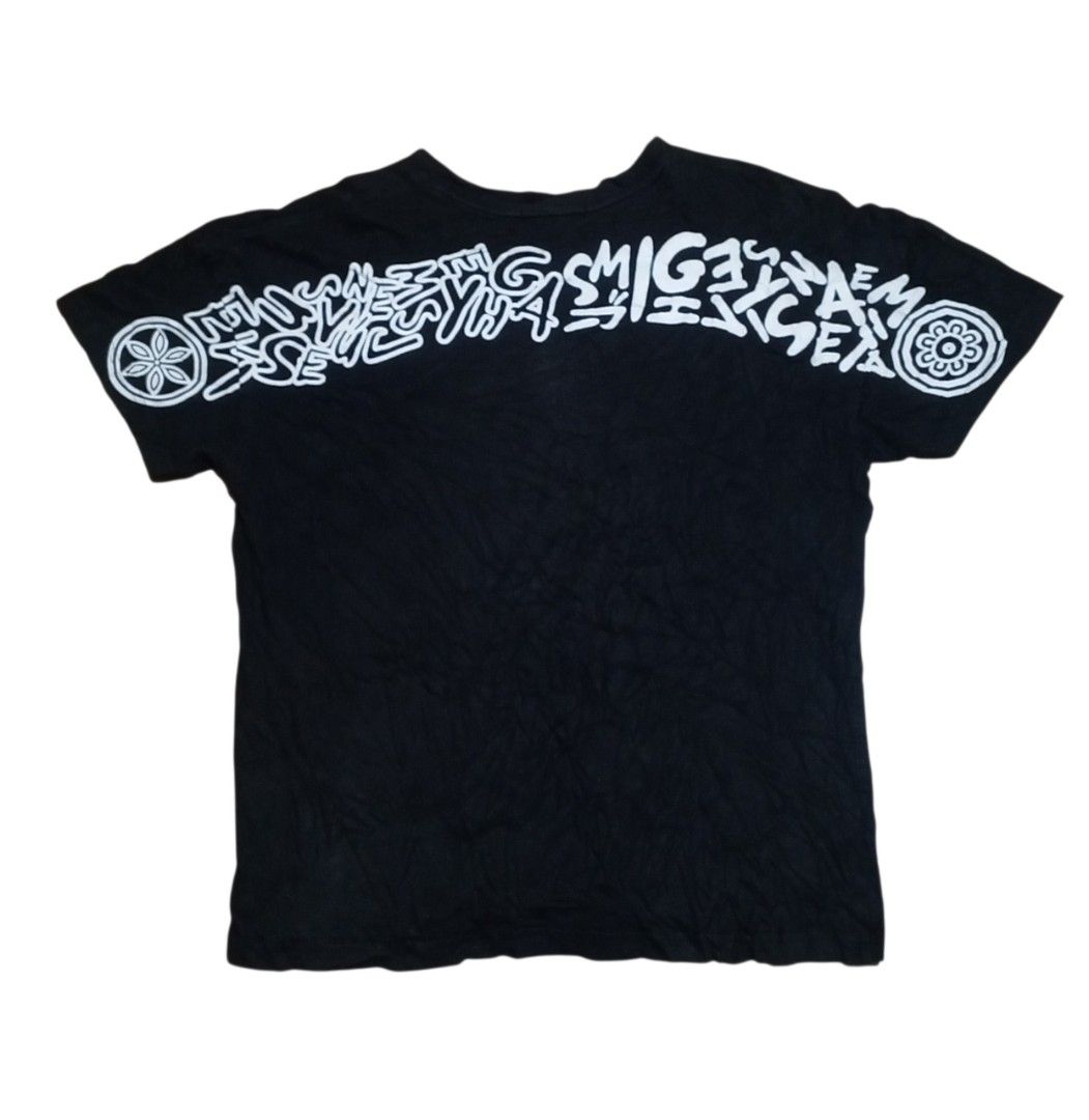 Evisu Black Graphic T-Shirt (Category: Tshirts & Polo Shirts ) located in Manila. Submitted by kents_thrift (Listing ID 1466971374, Image 2). Description: - Brand: Evisu Premium Quality - Color: Black - Size: 100 - Design: Small white seagull logo on left chest, large graffiti-style lettering across upper back, and round crest graphics on both sleeves - Authenticity: Includes official interior authentication label and collar tag.