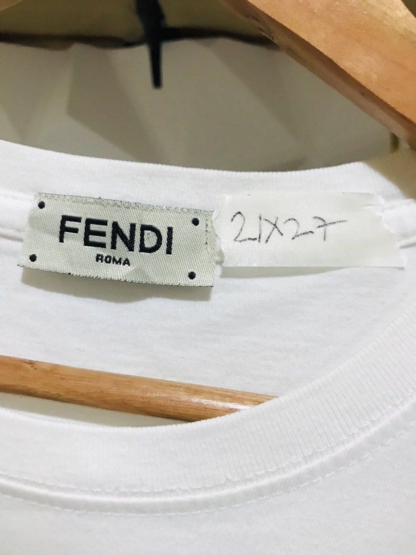 Fendi Roma Graphic Print White T-Shirt (Category: Luxury Apparel) located in Rizal. Submitted by drthriftone (Listing ID 1466972779, Image 2). Description: White graphic tee from Fendi Roma. Front features distinctive artwork with sandals and bold blue lettering. Crew neck design and short sleeves. Tag marked 21x27. Standard cotton t-shirt cut. Clean surface, solid collar ribbing, brand tag stitched at the inner neckline. Ready to wear..