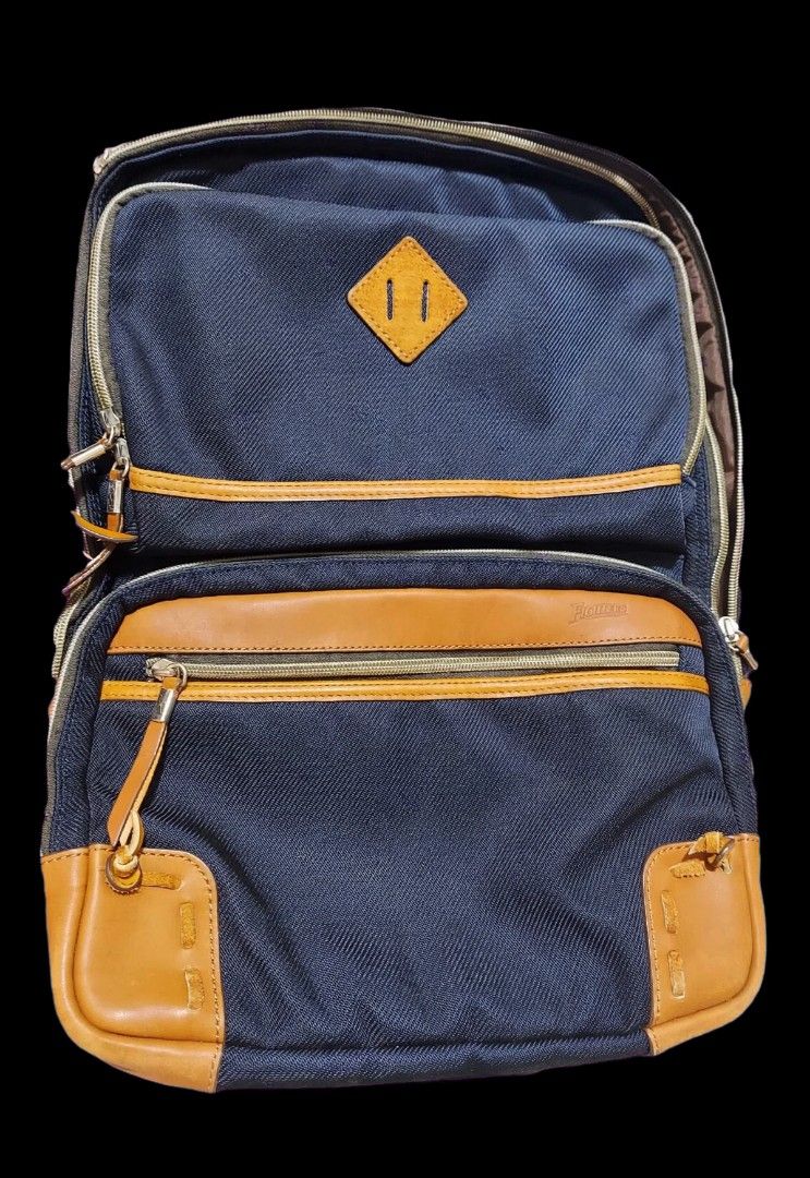 Mizuno Fighters Navy Blue and Tan Leather Accent Backpack (Category: Backpacks) located in Caloocan City. Submitted by chonadura91470 (Listing ID 1467103742, Image 3). Description: - Color: Navy blue with brown leather trim and accents - Storage: Multiple internal compartments and front zipper pockets - Comfort: Padded mesh shoulder straps and back panel - Details: Classic diamond lash tab patch and solid zippers with leather pull tabs - Conditio