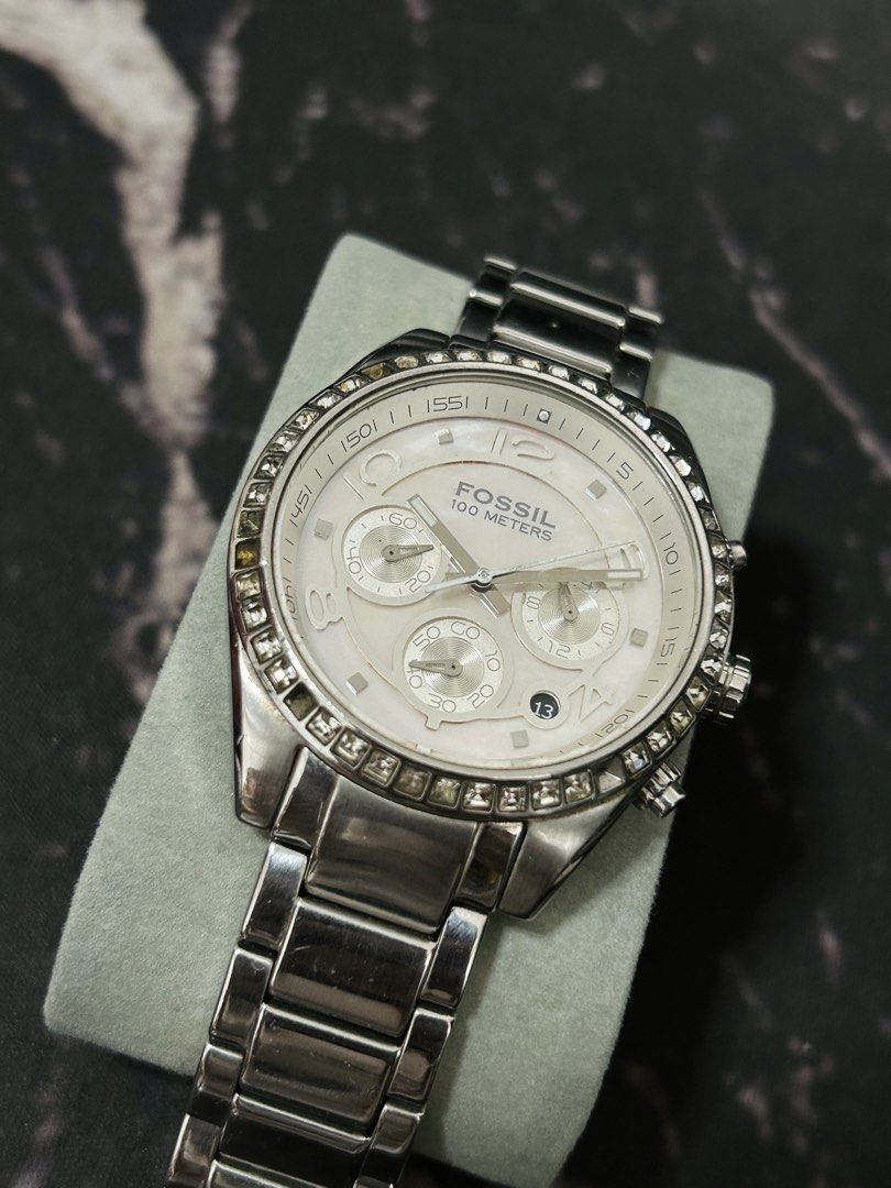Fossil 100 Meters Chronograph Watch with Crystals (Category: Women's Watches) located in Manila. Submitted by jehielash (Listing ID 1467014993, Image 3). Description: ‼️ AUTHENTIC ‼️ - Brand: Fossil - Color: Silver tone with a shimmering mother-of-pearl dial - Features: Chronograph with 3 sub-dials, date window at 4 o'clock, and dazzling crystal bezel - Material: Stainless steel link bracelet with secure deployment clasp - Condition: Well-maintai