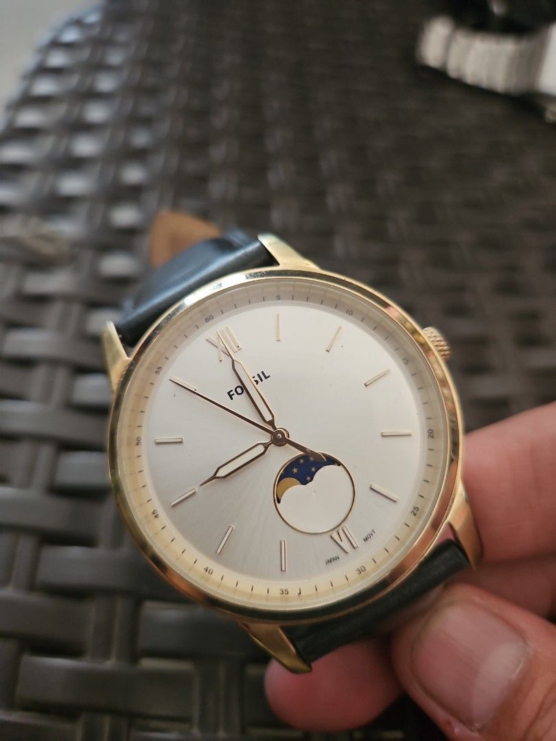 Fossil Gold Moonphase Watch with Black Leather Strap (Category: Men's Watches) located in Santa Maria. Submitted by rommelmateo (Listing ID 1466974173, Image 1). Description: - Brand: Fossil - Design: Classic gold-tone dress watch with a white dial - Features: Moonphase subdial at 3 o'clock, Roman numerals at 6 and 12, stick markers - Strap: Genuine black leather with buckle closure - Build & Durability: All stainless steel case, 5 ATM water resi