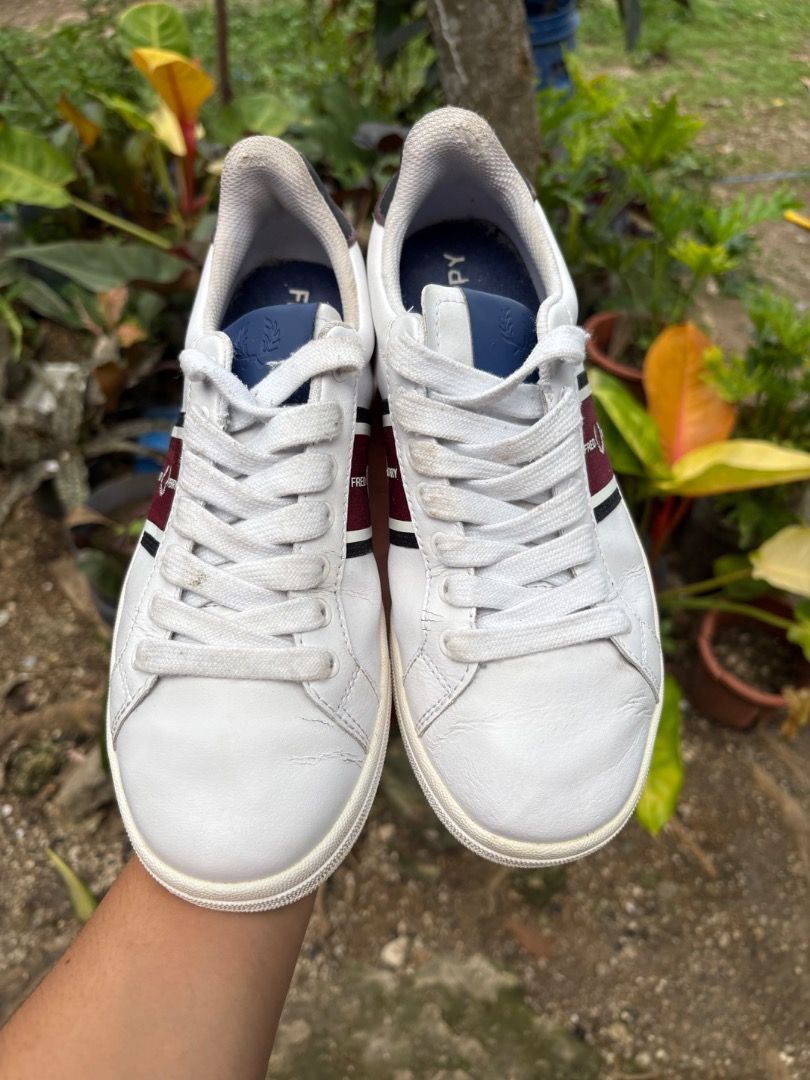 Fred Perry White Leather Sneakers with Stripe (Category: Sneakers) located in Danao, Cebu. Submitted by kentoy25 (Listing ID 1467026472, Image 2). Description: - Brand: Fred Perry - Material: White leather - Design: Burgundy and black side stripes with blue tongue accents - Details: Contrast black heel tabs featuring embroidered laurel wreath logo - Condition: Clean uppers with minor toe creasing; textured rubber soles with minimal tread wear - I