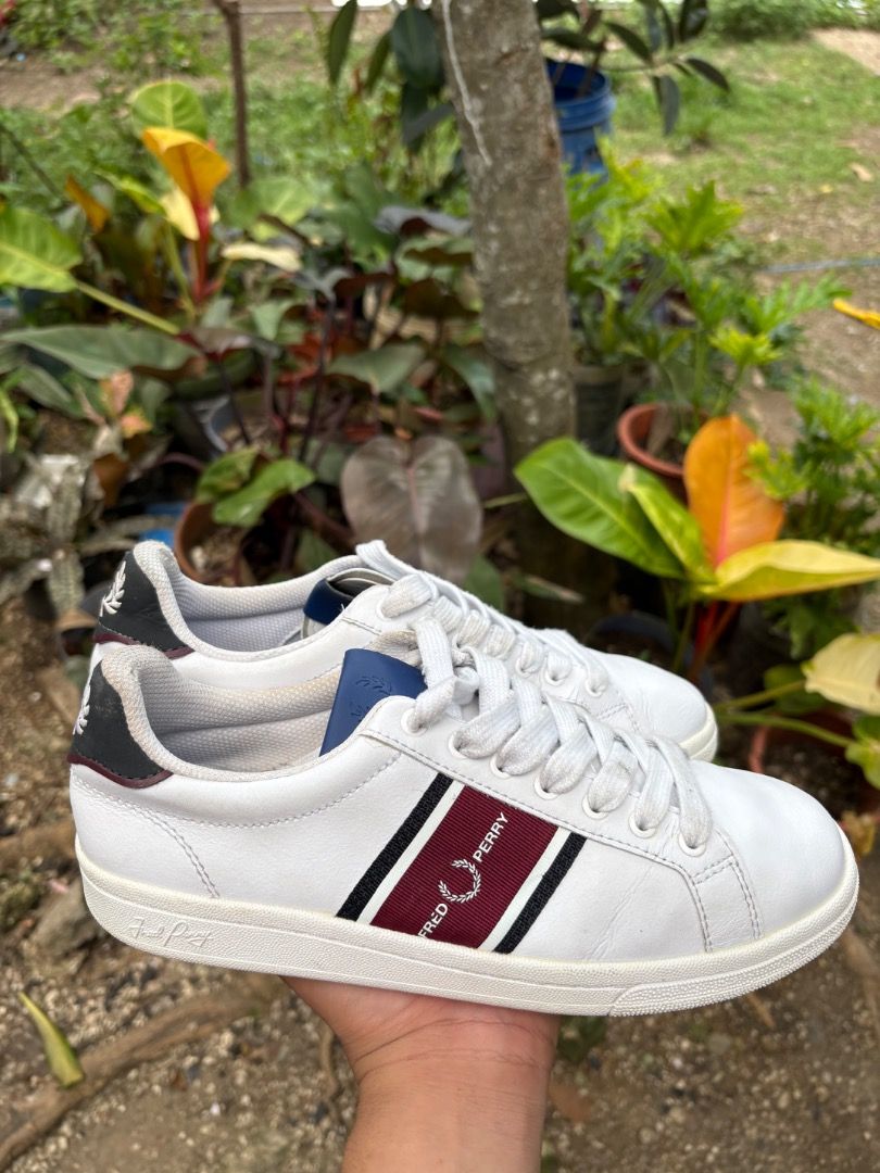 Fred Perry White Leather Sneakers with Stripe (Category: Sneakers) located in Danao, Cebu. Submitted by kentoy25 (Listing ID 1467026472, Image 1). Description: - Brand: Fred Perry - Material: White leather - Design: Burgundy and black side stripes with blue tongue accents - Details: Contrast black heel tabs featuring embroidered laurel wreath logo - Condition: Clean uppers with minor toe creasing; textured rubber soles with minimal tread wear - I