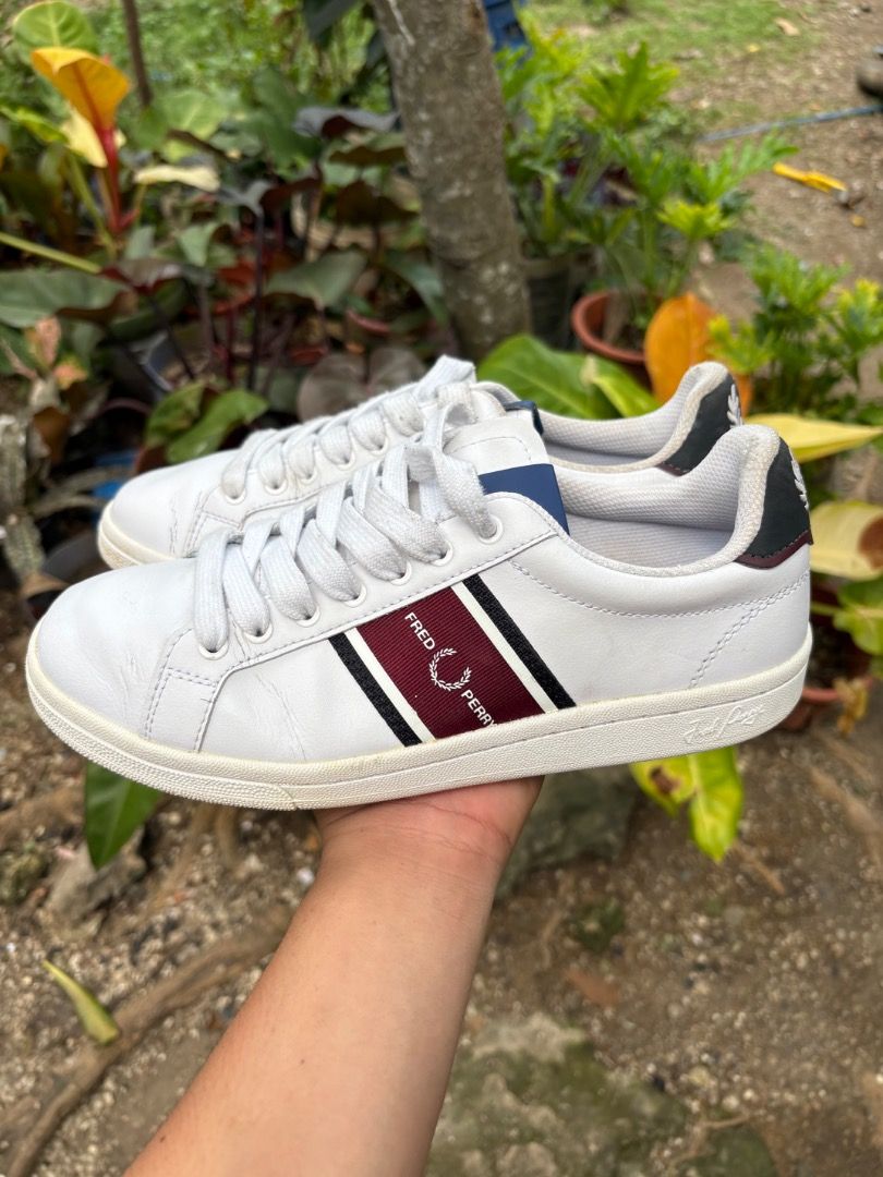 Fred Perry White Leather Sneakers with Stripe (Category: Sneakers) located in Danao, Cebu. Submitted by kentoy25 (Listing ID 1467026472, Image 3). Description: - Brand: Fred Perry - Material: White leather - Design: Burgundy and black side stripes with blue tongue accents - Details: Contrast black heel tabs featuring embroidered laurel wreath logo - Condition: Clean uppers with minor toe creasing; textured rubber soles with minimal tread wear - I