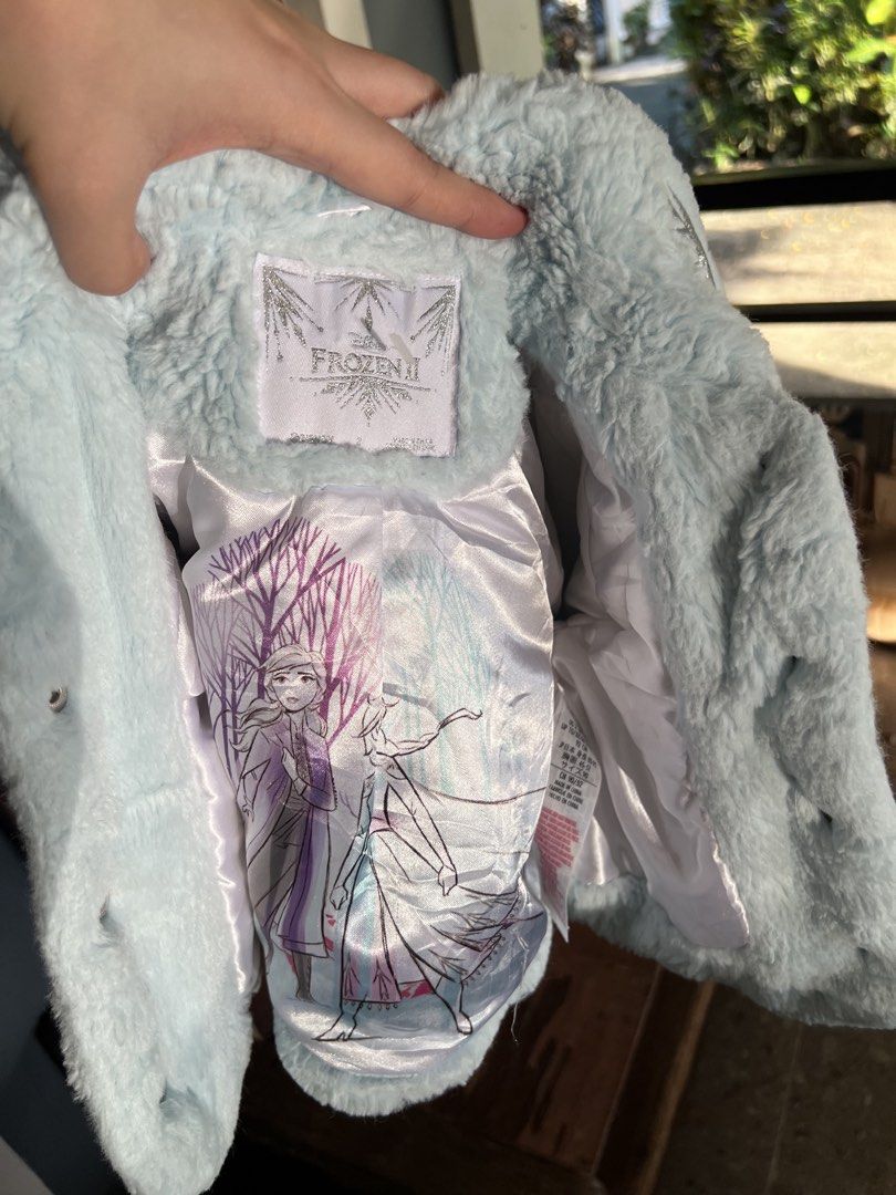 Frozen II Blue Faux Fur Winter Jacket (Category: Babies & Kids Fashion) located in Manila. Submitted by itsmeajie (Listing ID 1467048645, Image 3). Description: - 100% Official Frozen II merchandise - Light blue faux fur jacket with shiny silver snowflake embroidery - Beautiful satin lining featuring printed graphics of Anna and Elsa - Fun button-up front with sparkly buttons - Soft, cozy, and warm for everyday wear - Perfect gift or wardrobe add