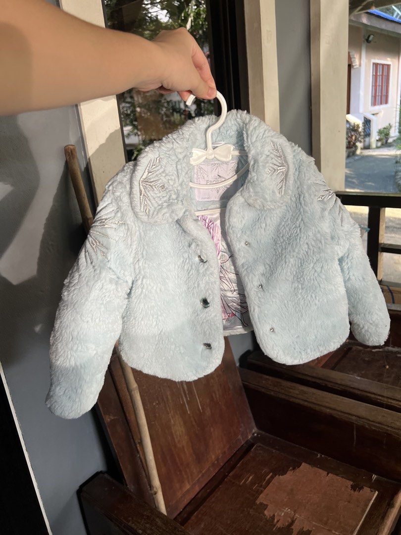 Frozen II Blue Faux Fur Winter Jacket (Category: Babies & Kids Fashion) located in Manila. Submitted by itsmeajie (Listing ID 1467048645, Image 2). Description: - 100% Official Frozen II merchandise - Light blue faux fur jacket with shiny silver snowflake embroidery - Beautiful satin lining featuring printed graphics of Anna and Elsa - Fun button-up front with sparkly buttons - Soft, cozy, and warm for everyday wear - Perfect gift or wardrobe add