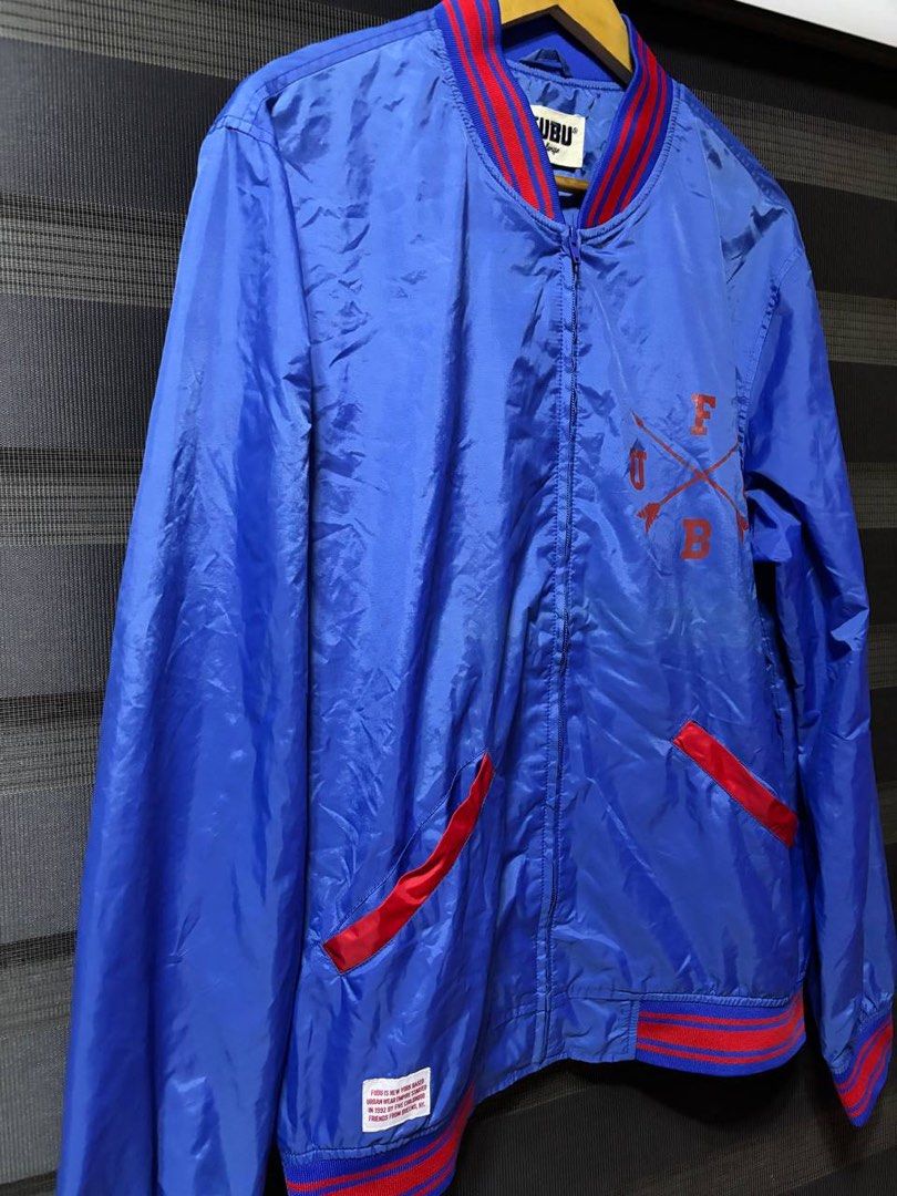 FUBU Blue Red Bomber Jacket (Category: Coats, Jackets and Outerwear) located in Pasig City. Submitted by abogadosupremo (Listing ID 1467028761, Image 3). Description: - Brand: FUBU - Item: Varsity Bomber Jacket - Color: Blue and red - Design: Full zip front, ribbed collar and cuffs with red stripes, mesh inner lining - Graphics: Front chest graphic with cross arrows and brand lettering, plus a heritage patch detailing FUBU's Queens, NY roots - Po
