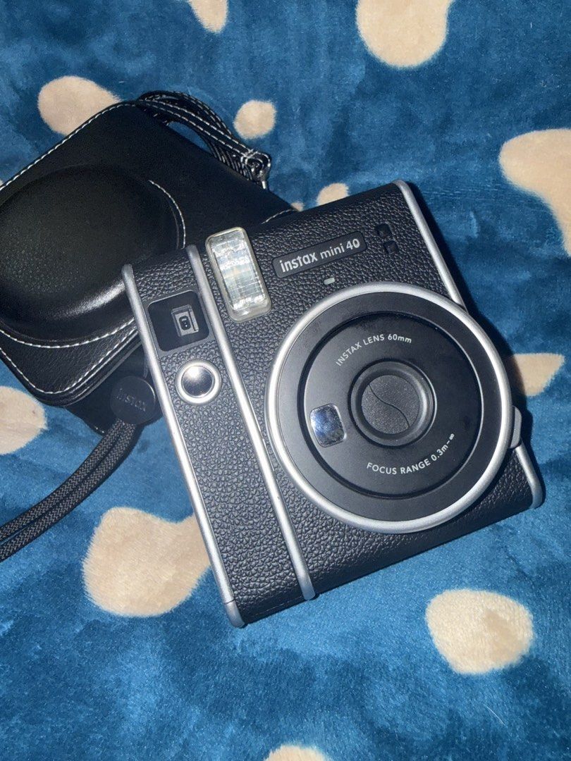 Fujifilm Instax Mini 40 Instant Camera with Case (Category: Cameras) located in Manila. Submitted by jai.evnglsta (Listing ID 1467141653, Image 2). Description: - Camera Model: Fujifilm Instax Mini 40 with a classic black textured finish - Inclusions: Matching black leatherette fitted case with an adjustable shoulder strap - Features: Built-in flash and 60mm lens for effortless shooting - Film Type: Uses standard Instax Mini film (not included) -