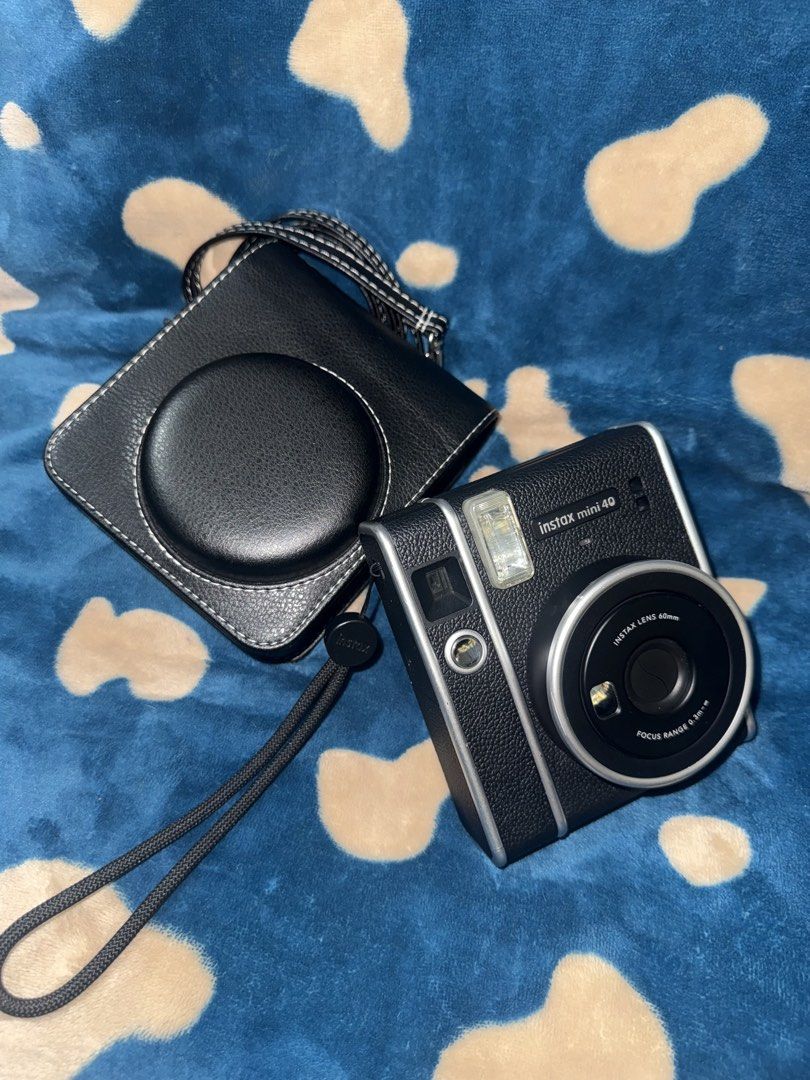 Fujifilm Instax Mini 40 Instant Camera with Case (Category: Cameras) located in Manila. Submitted by jai.evnglsta (Listing ID 1467141653, Image 1). Description: - Camera Model: Fujifilm Instax Mini 40 with a classic black textured finish - Inclusions: Matching black leatherette fitted case with an adjustable shoulder strap - Features: Built-in flash and 60mm lens for effortless shooting - Film Type: Uses standard Instax Mini film (not included) -