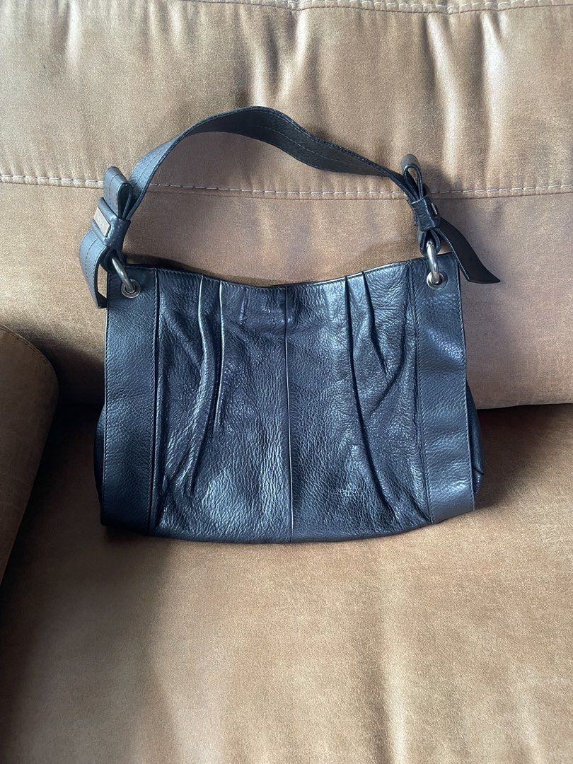Furla Black Leather Shoulder Bag (Category: Luxury Bags & Wallets) located in Muntinlupa City. Submitted by phbudgetluxuryfinds (Listing ID 1466986959, Image 1). Description: - Brand: Furla - Material: Genuine black leather - Design: Elegant ruched front panel with silver-tone hardware - Strap: Single strap featuring an embossed metal logo plaque on the base - Interior: Cute black fabric lining with white polka dots and a convenient zippered side