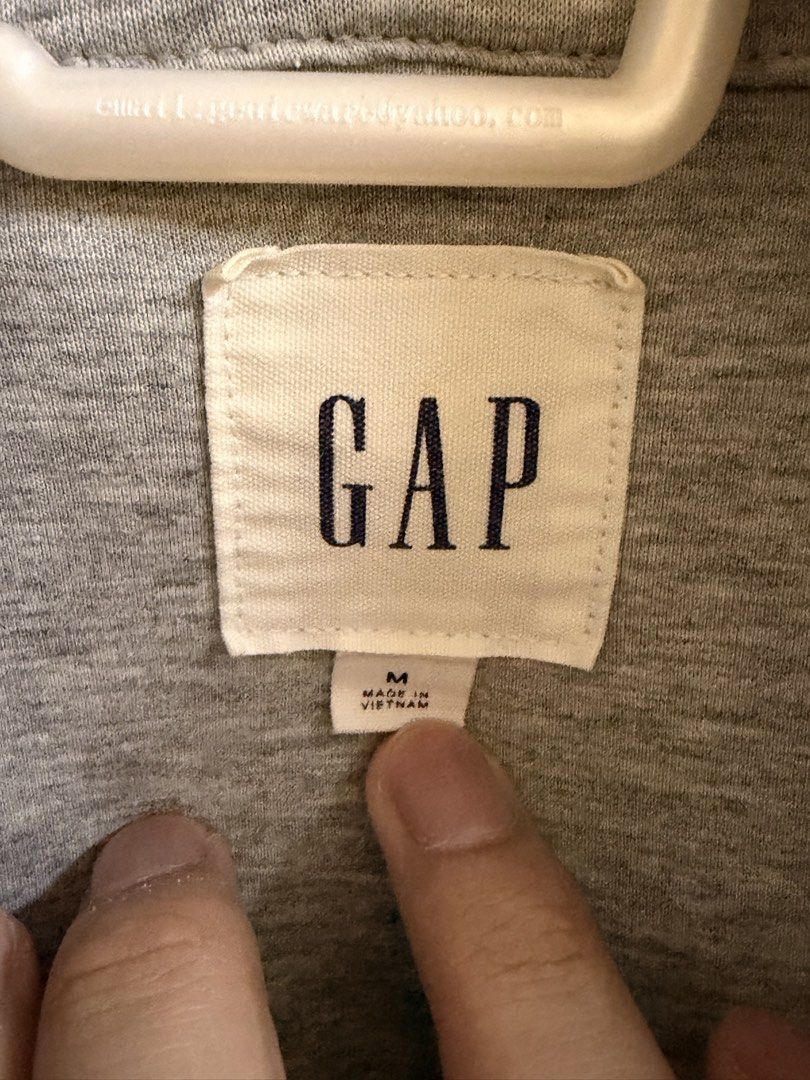 GAP Heather Grey Full Zip Hoodie Size M (Category: Coats, Jackets and Outerwear) located in Manila. Submitted by lanzblade (Listing ID 1467063596, Image 2). Description: - Brand: Gap - Style: Full zip hoodie with attached hood - Color: Heather grey with contrasting black drawstrings - Size: Medium (Made in Vietnam) - Pockets: Two front hand pockets plus a stylish zippered front chest pocket - Details: Subtle Gap logo tag near the hem, ribbed cuff