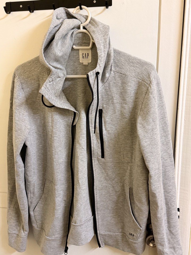 GAP Heather Grey Full Zip Hoodie Size M (Category: Coats, Jackets and Outerwear) located in Manila. Submitted by lanzblade (Listing ID 1467063596, Image 1). Description: - Brand: Gap - Style: Full zip hoodie with attached hood - Color: Heather grey with contrasting black drawstrings - Size: Medium (Made in Vietnam) - Pockets: Two front hand pockets plus a stylish zippered front chest pocket - Details: Subtle Gap logo tag near the hem, ribbed cuff
