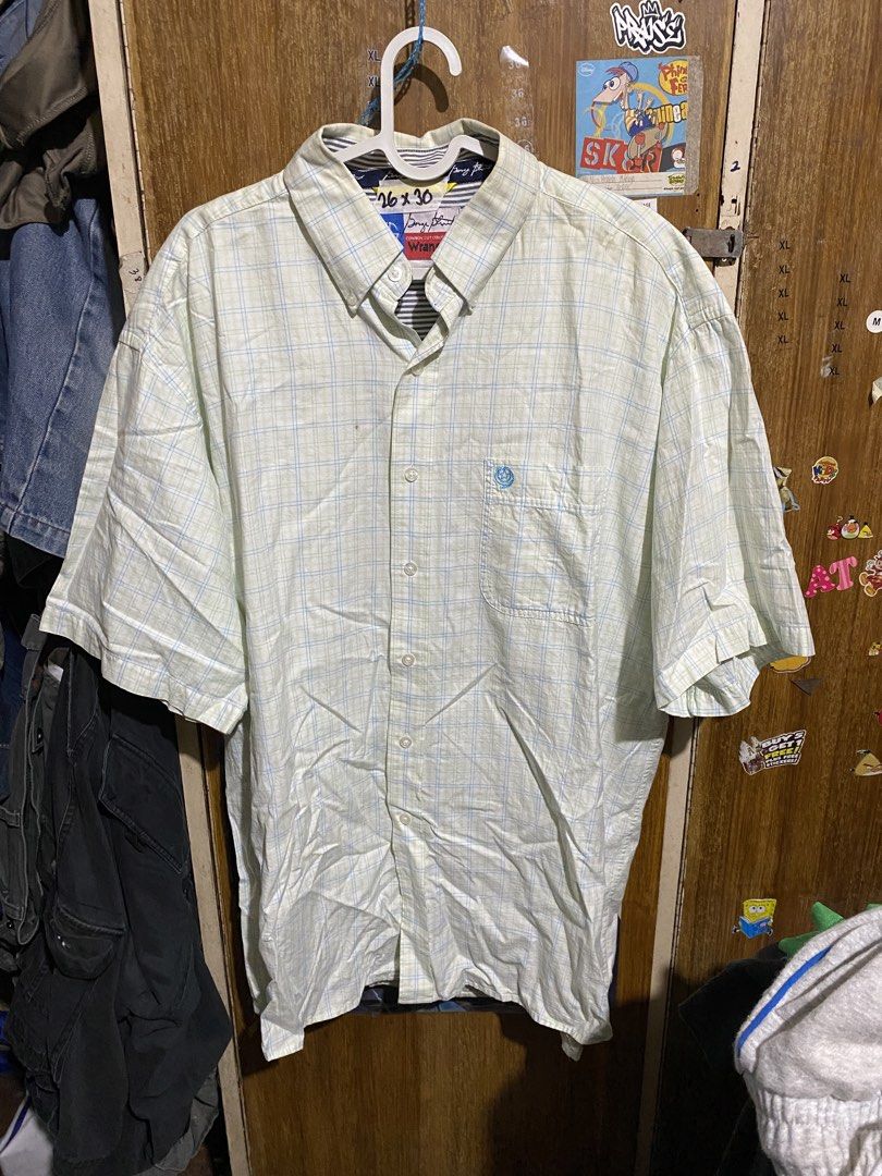 George Strait Wrangler Cowboy Cut Button Down Shirt (Category: Tshirts & Polo Shirts ) located in Imus. Submitted by frootiloots4103 (Listing ID 1467152987, Image 1). Description: - Brand: George Strait Cowboy Collection by Wrangler - Style: Short sleeve button-down shirt - Pattern: Light green and blue plaid - Details: Striped collar lining, blue contrasting tape inside, single chest pocket with blue embroidered logo - Size: 26" x 30" (based on 