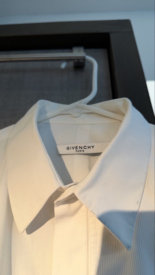 Givenchy Paris White Long Sleeve Shirt (Category: Formal Shirts) located in Makati City. Submitted by tomascz (Listing ID 1466983167, Image 3). Description: - Brand: Givenchy Paris - Color: Classic White - Style: Long-sleeve button-down with concealed placket - Details: Textured front bib with stylish metal bar hardware - Fit: Classic fit, fits true to size - Hem: Standard curved hemline - Condition: Used this a lot — has a lot of dark marks and 