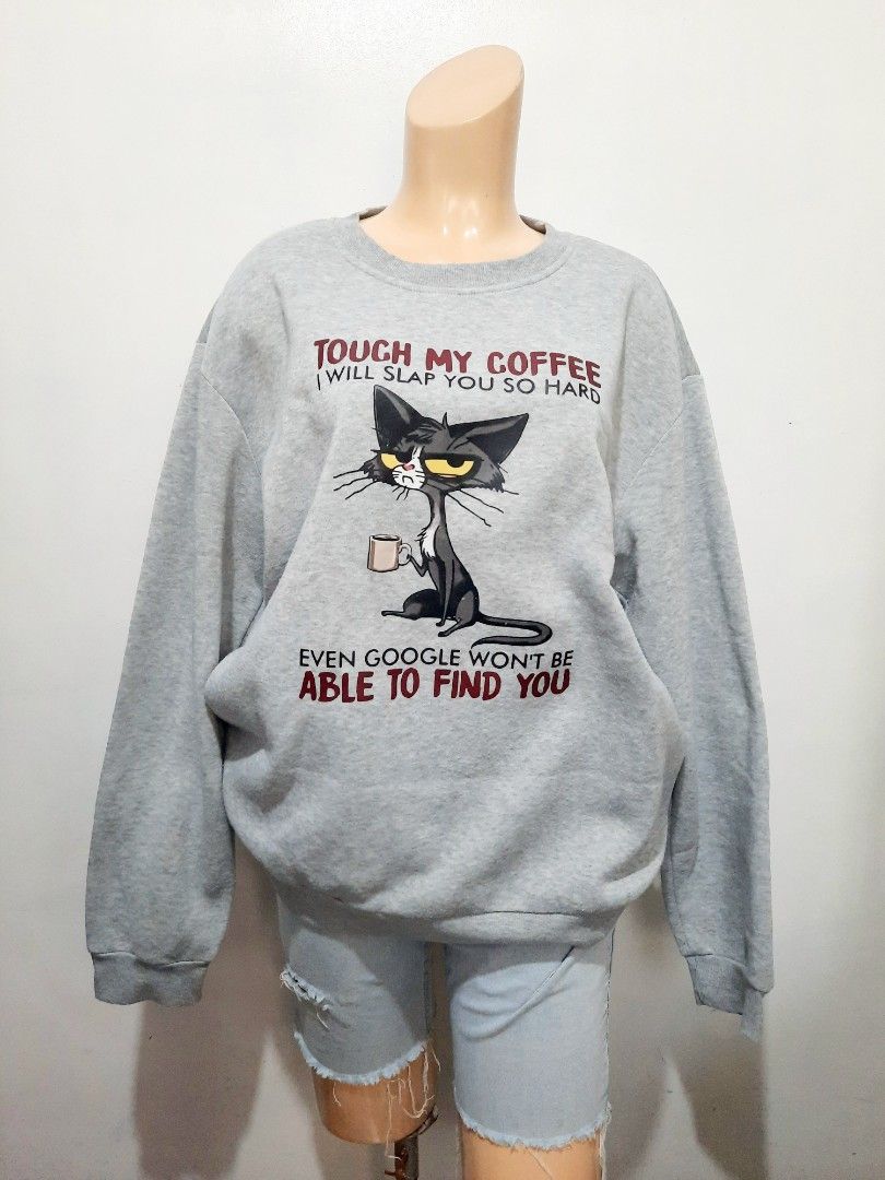 Grey Cat Coffee Sweatshirt - Funny Graphic Print (Category: Longsleeves) located in Cavite. Submitted by YANAminicloset (Listing ID 1463848236, Image 1). Description: - Grey long-sleeved sweatshirt -XL - Features a funny cat - Crew neck design - Comfortable and casual style - Ideal for coffee enthusiasts and cat lovers.