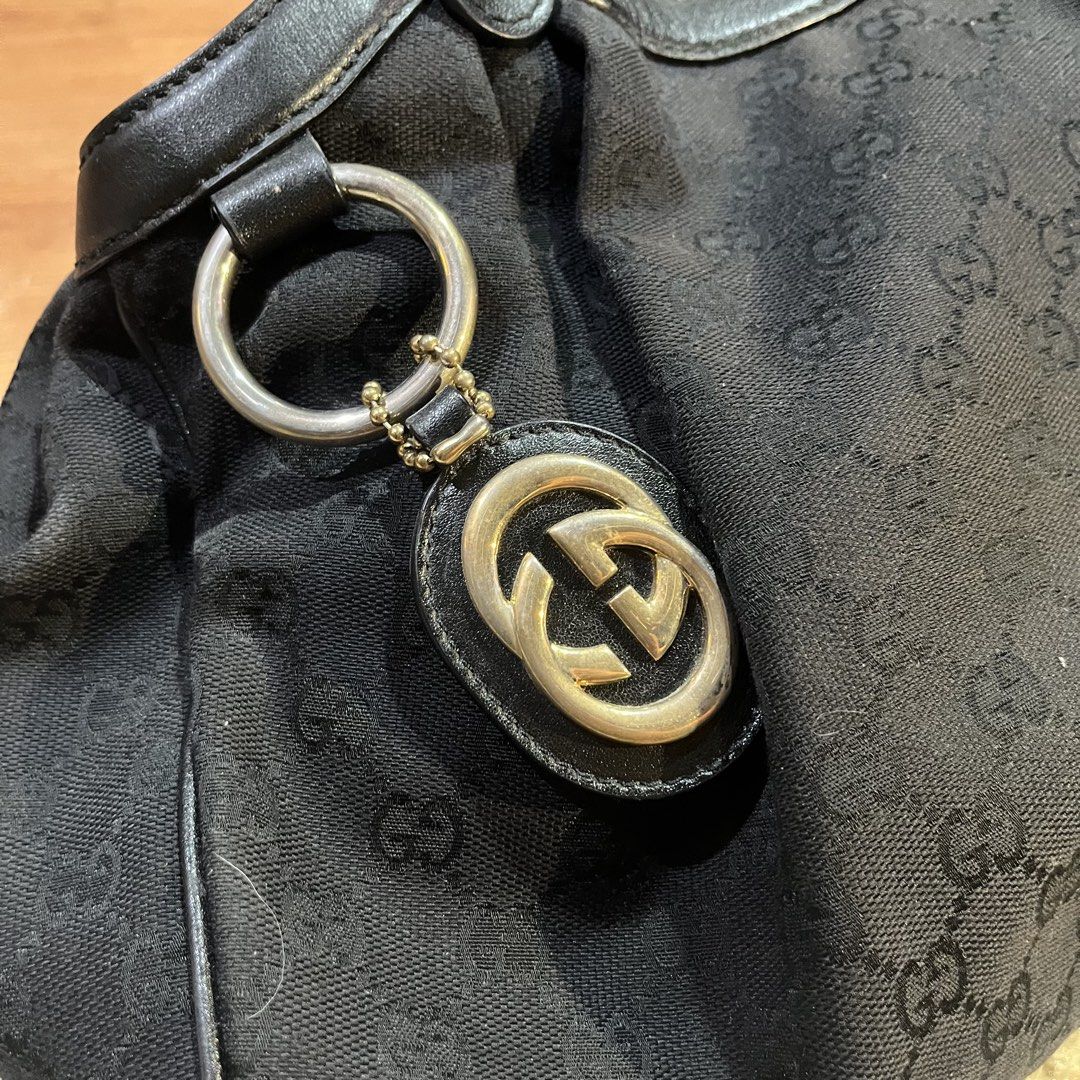 Gucci Black Sukey Tote bag (Category: Luxury Bags & Wallets) located in Binan City. Submitted by jdshoppee (Listing ID 1467142650, Image 2). Description: - Brand: Gucci - Style: Monogram Canvas Tote Bag - Color: Black canvas with cream interior, brown leather handles/trim - Hardware: Gold-tone with Interlocking G logo charm - Interior: Light lining with zip pocket and Gucci Made in Italy tag - Condition: Good exterior, with visible stains and wea