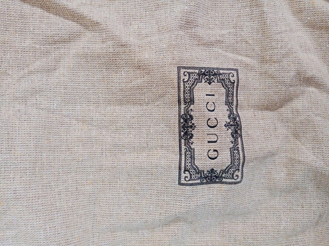 Gucci branded dust bag with drawstring (Category: Luxury Bags & Wallets) located in Lucban. Submitted by aeronroyyy (Listing ID 1466986656, Image 1). Description: - 100% Authentic Gucci dust bag - Material: 88% cotton, 12% polyester - Color: Beige with a vintage-style black Gucci logo on the front - Closure: Secure black drawstring at the top - Care: Includes stitched-in interior care label with washing instructions - Condition: Excellent/Pristin