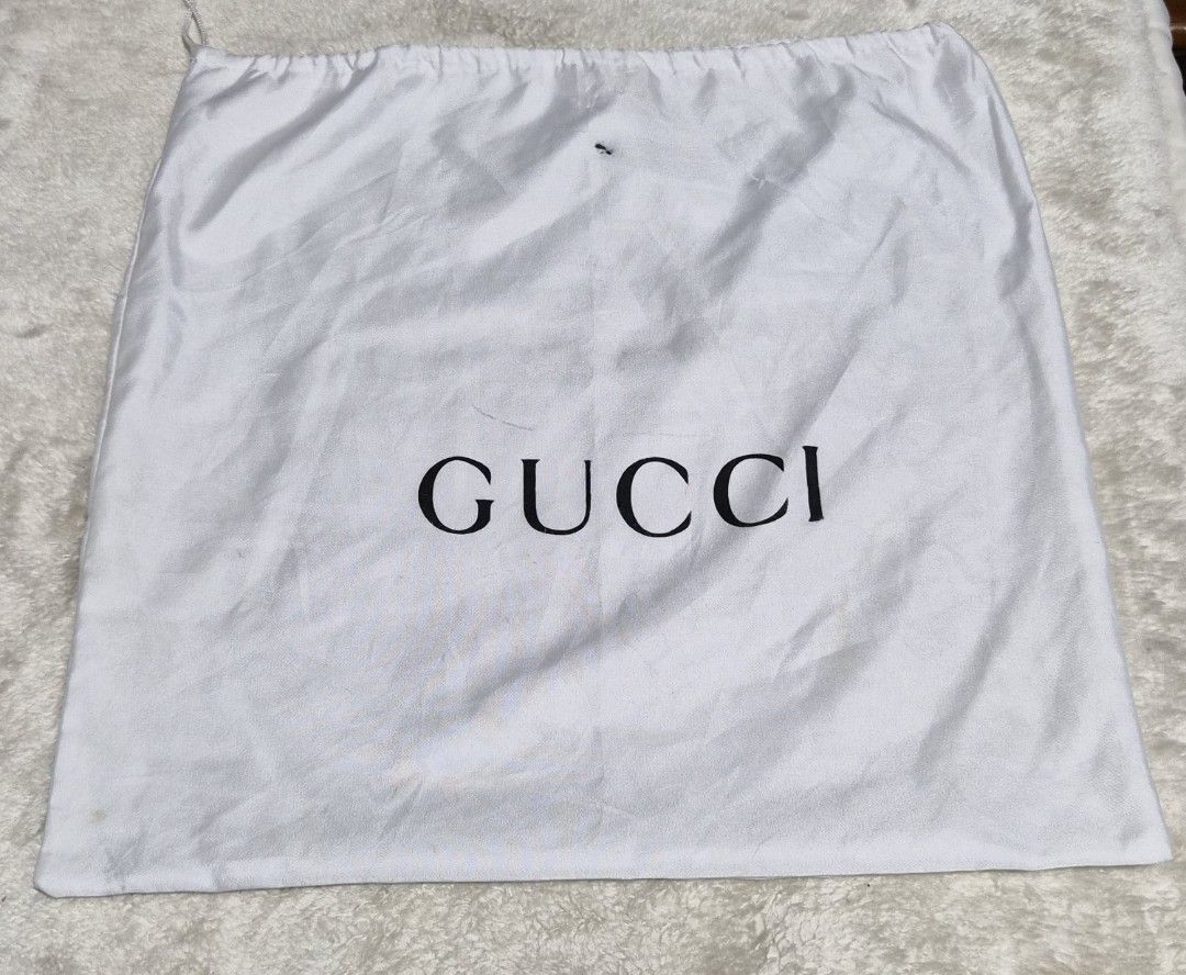 Gucci Dust Bag White Drawstring 14 x 15 inches (Category: Luxury Bags & Wallets) located in Mandaue City. Submitted by chuchi152615 (Listing ID 1466972368, Image 3). Description: - white Gucci dust bag featuring the classic black logo lettering - Convenient drawstring closure at the top - Dimensions: Approximately 14 inches x 14.5 inches - Condition: Has some minor smudges and small marks on the fabric surface - Ideal for storing designer bags an