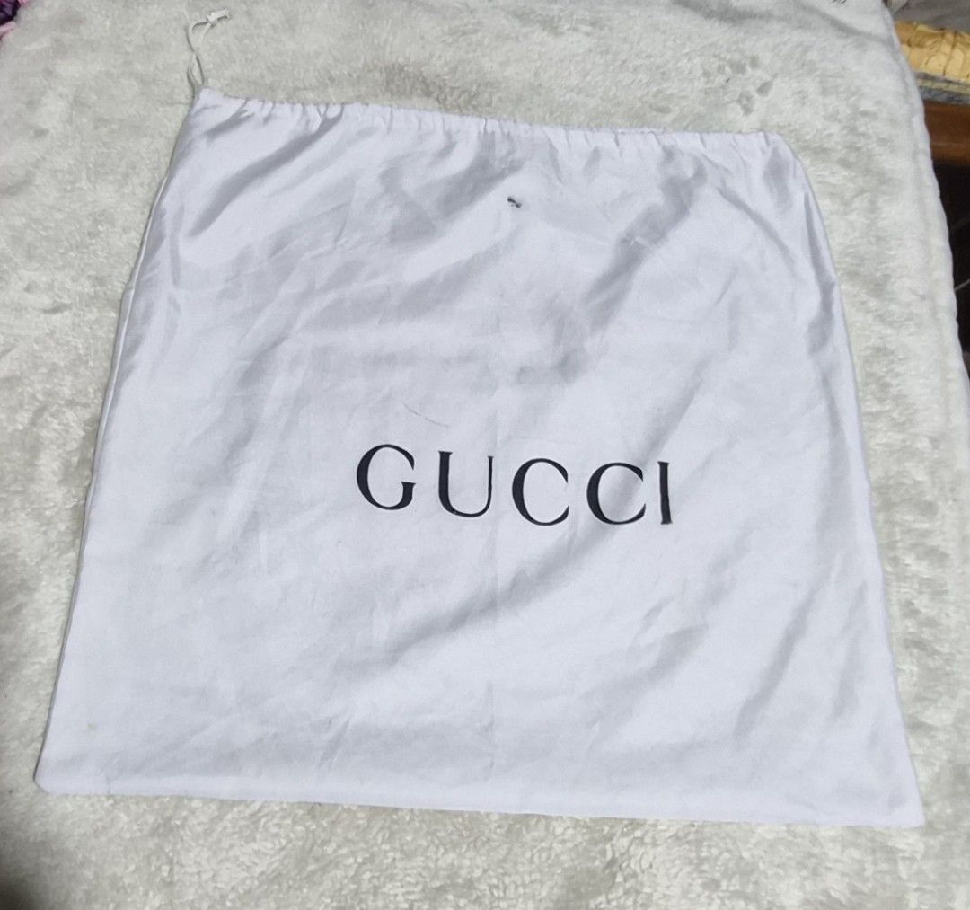 Gucci Dust Bag White Drawstring 14 x 15 inches (Category: Luxury Bags & Wallets) located in Mandaue City. Submitted by chuchi152615 (Listing ID 1466972368, Image 1). Description: - white Gucci dust bag featuring the classic black logo lettering - Convenient drawstring closure at the top - Dimensions: Approximately 14 inches x 14.5 inches - Condition: Has some minor smudges and small marks on the fabric surface - Ideal for storing designer bags an