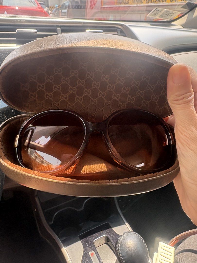 Gucci Sunglasses with Hard Case (Category: Sunglasses & Eyewear) located in Manila. Submitted by rgolpeo (Listing ID 1467121560, Image 2). Description: - Brand: Gucci - Style: Oversized sunglasses with dark brown gradient lenses - Hardware: Gold-tone frames and temples - Condition (Glasses): Clean and ready to wear - Inclusions: Original bronze hard case with GG monogram interior lining - Note on Case: Exterior has visible scratches and surface w