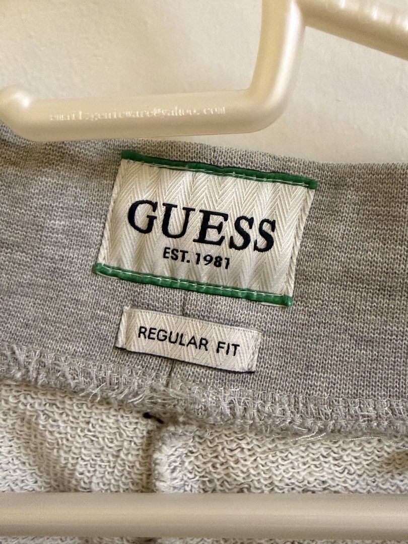 Guess Grey Regular Fit Sweatpants (Category: Joggers) located in Manila. Submitted by lanzblade (Listing ID 1467063600, Image 3). Description: - Brand/Style: Guess regular-fit grey sweatpants - Waist: Drawstring waist with metal aglets - Details: Small blue embroidered logo and address text on the front left leg - Pockets: Convenient side pockets and a single welt pocket on the back right - Cuffs: Ribbed cuffs at the ankles - Material: Soft cotto