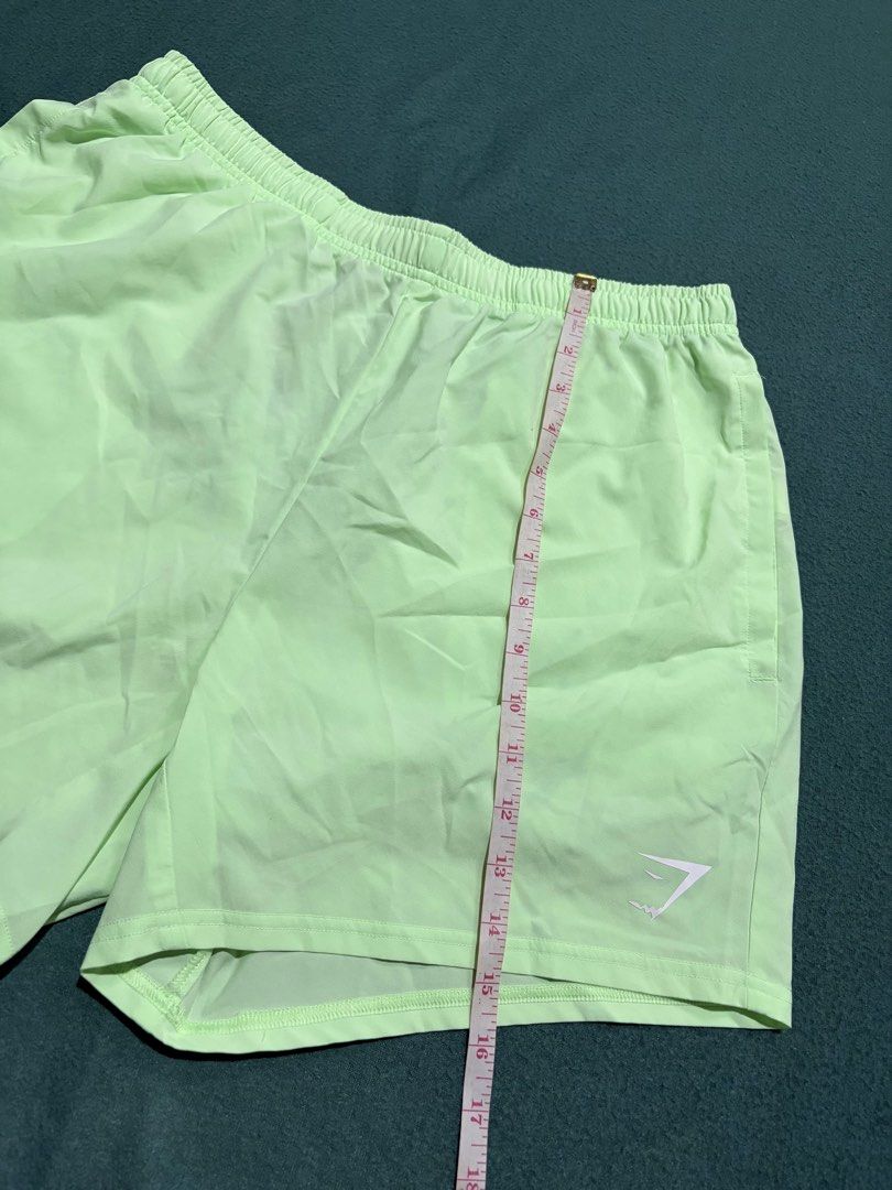 Gymshark Light Green Athletic Shorts Size L (Category: Shorts) located in Guihulngan. Submitted by fbthriftgoodsniace (Listing ID 1467094478, Image 2). Description: - Brand: Gymshark - Color: Light green - Size: L (tag inside waistband) - Features: Side pockets, black adjustable drawstring with Gymshark branding, white logo near hem - Material: Lightweight, ideal for workouts or running - Measurements: ~18" across the waist, ~18" total length -Ne