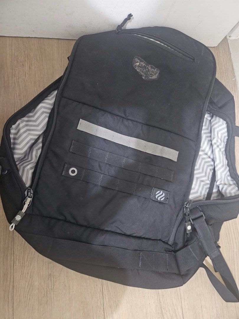 Haimplanet monolith 40L Black travel backpack with chevron interior lining and multiple compartments (Category: Backpacks) located in Taguig. Submitted by joyvillanueva (Listing ID 1466971996, Image 3). Description: - Color: Sleek black with a grey chevron pattern inside - Storage: Wide-opening main compartment with dual mesh zip pockets and a front top pocket - Exterior: Features modular webbing strips and a safety reflective stripe - Comfort: P