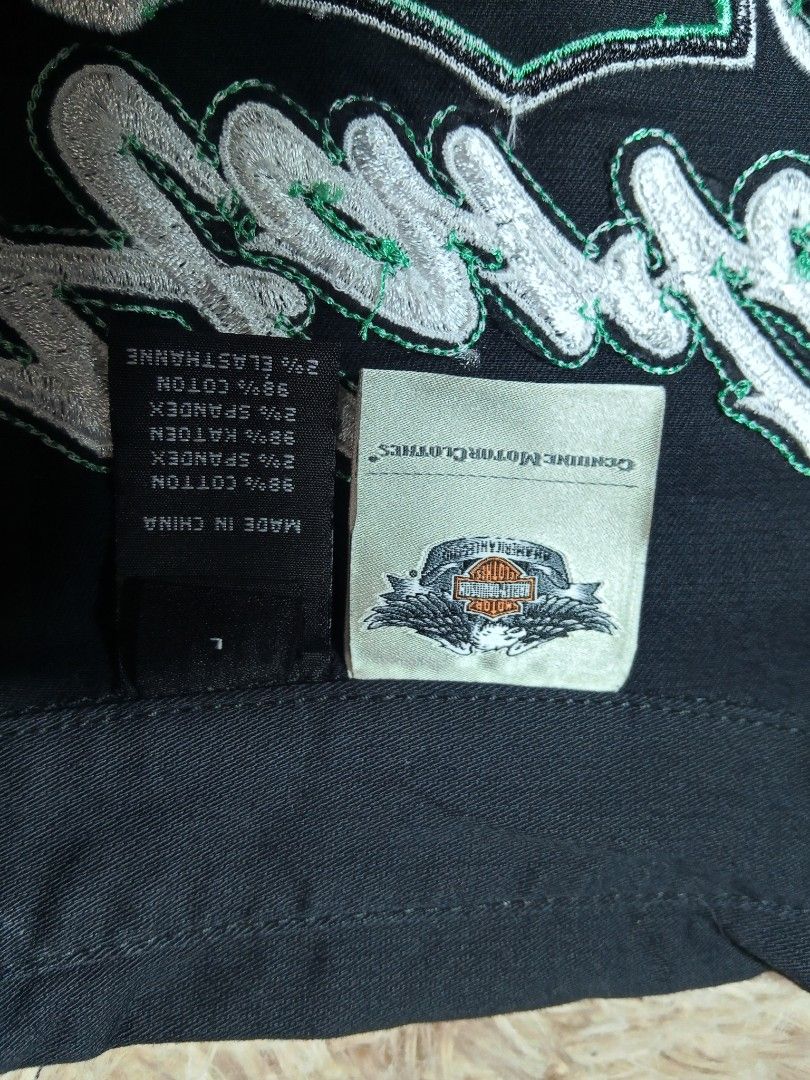 Harley Davidson Black Embroidered Zip Vest Size L (Category: Vests) located in Lucban. Submitted by aeronroyyy (Listing ID 1466988362, Image 3). Description: Black Harley-Davidson sleeveless zip-up vest in size Large. White and green embroidery lettering and graphics across the back and front chest. Metal branded zipper pull. Corset-style lace-up back detail with grommets. Collared neckline with two front chest pockets. 98 percent cotton and 2 pe