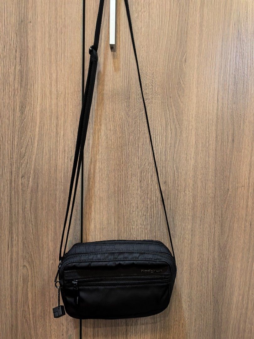 Hedgren Black Nylon Crossbody Bag (Category: Cross-body Bags) located in Manila. Submitted by maifabfinds (Listing ID 1467151123, Image 2). Description: - Brand: Hedgren - Color: Black - Material: Durable, lightweight nylon - Strap: Adjustable shoulder strap for custom fit - Organization: Multiple zippered compartments for secure storage - Extra: Cute cube charm attached to the front zip pocket - Condition: Excellent daily carry bag.