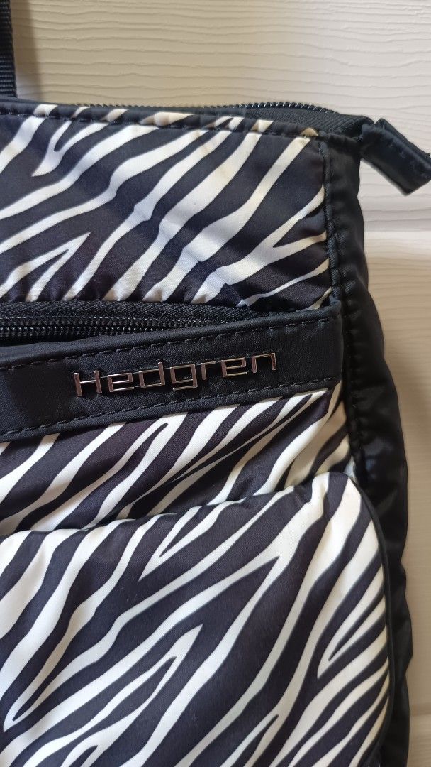 Hedgren Zebra Print Tote Bag (Category: Tote Bags) located in Quezon City. Submitted by dhl.chx (Listing ID 1467082673, Image 2). Description: - Brand: Hedgren - Design: Stylish black and white zebra pattern with silver metallic hardware - Closure: Secure zip top - Exterior Storage: Two front flap pockets, a front zippered compartment, and a large back open pocket - Straps: Durable, comfortable fabric shoulder straps - Interior: Spacious main com