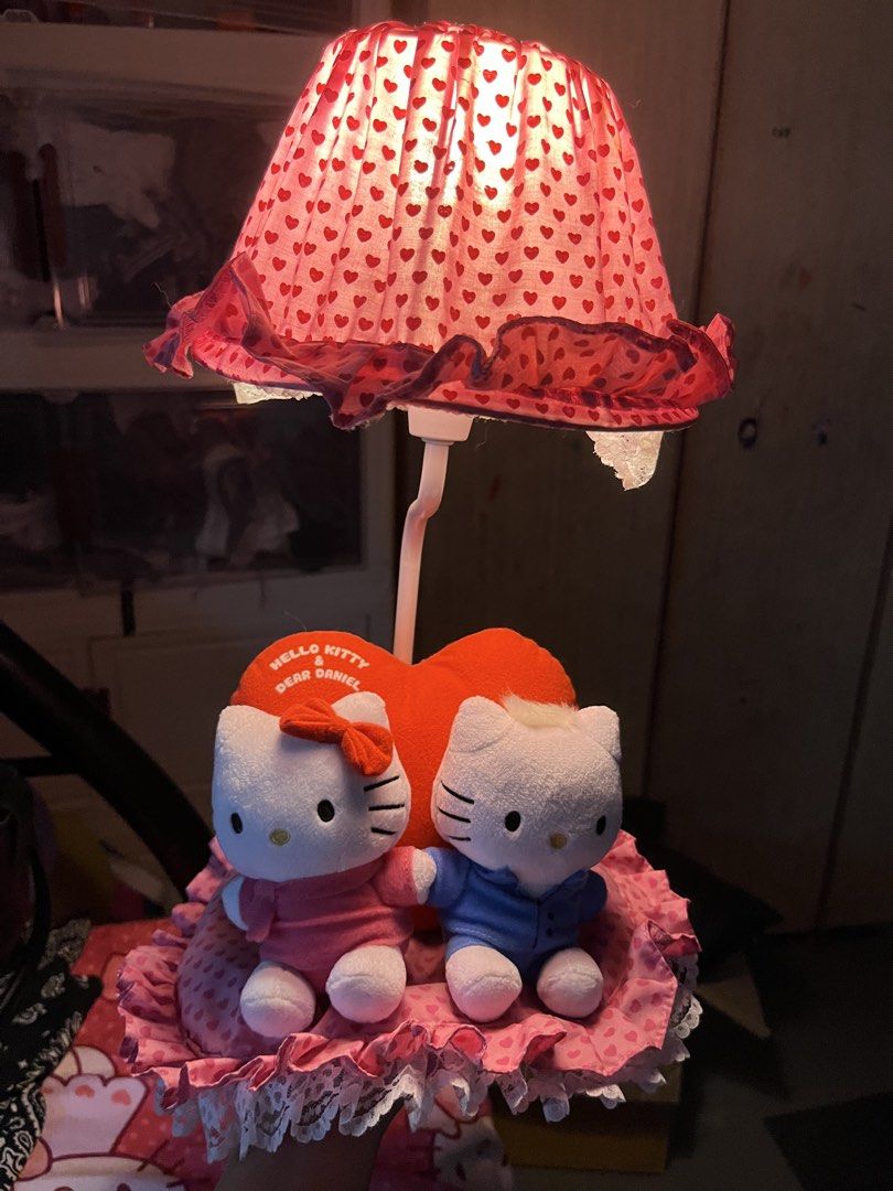 Hello Kitty and Dear Daniel desk lamp (Category: Lighting) located in Manila. Submitted by janetecson05 (Listing ID 1467004106, Image 1). Description: - Official Sanrio desk lamp featuring Kitty & Dear Daniel plushies on a heart cushion - Adorable pink lampshade with red hearts and ruffled lace trim - Fully working and ready to use - Perfect cute decor for your desk, vanity, or bedroom - Excellent addition to any Sanrio collection.