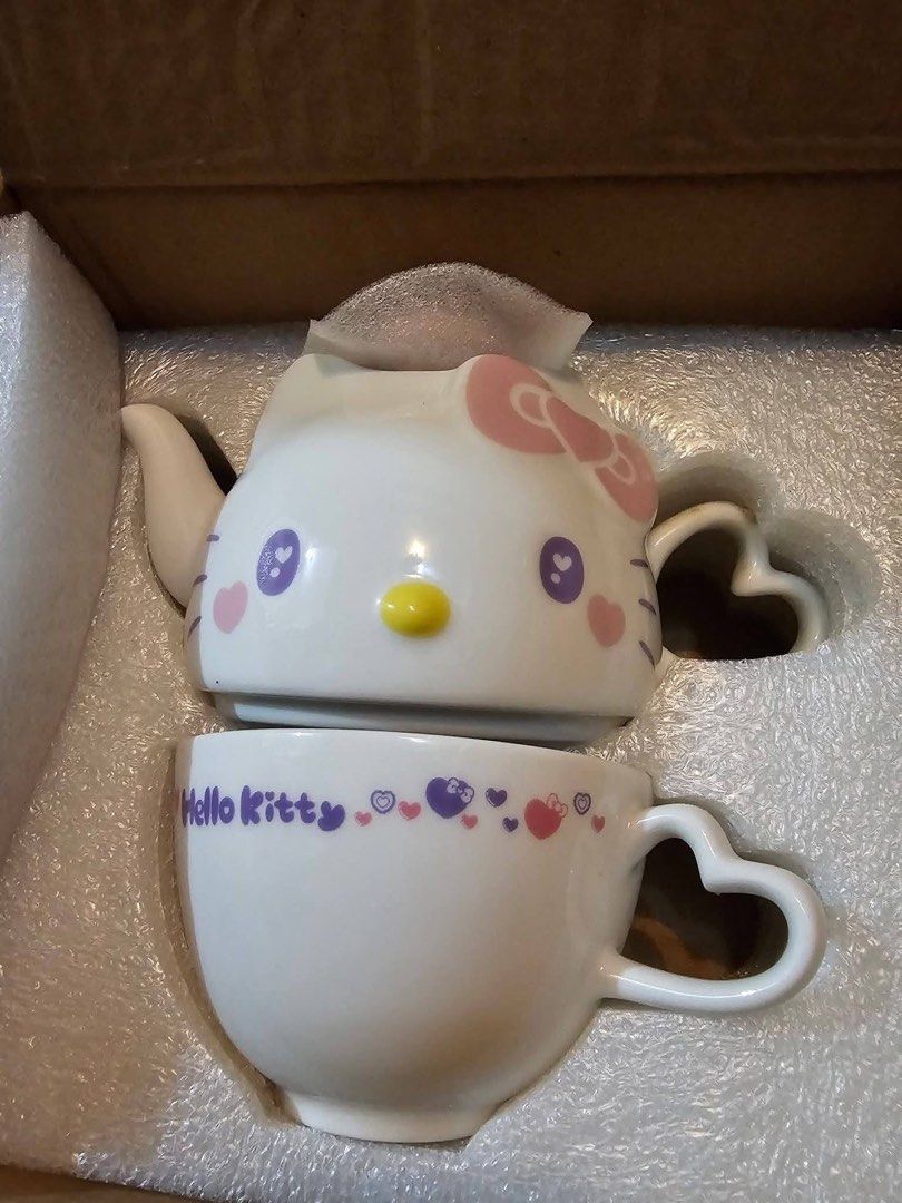 Hello Kitty Ceramic Teapot and Cup Set (Category: Coffee & Tea Tableware) located in Manila. Submitted by janetecson05 (Listing ID 1467007334, Image 1). Description: - Kitty ceramic tea for one set - Includes a teapot shaped like Kitty's head and a matching teacup with heart patterns - Both feature cute heart-shaped handles - Packed securely in original fitted styrofoam box with foam wrap - Ideal collectible set for Sanrio fans and tea lovers.