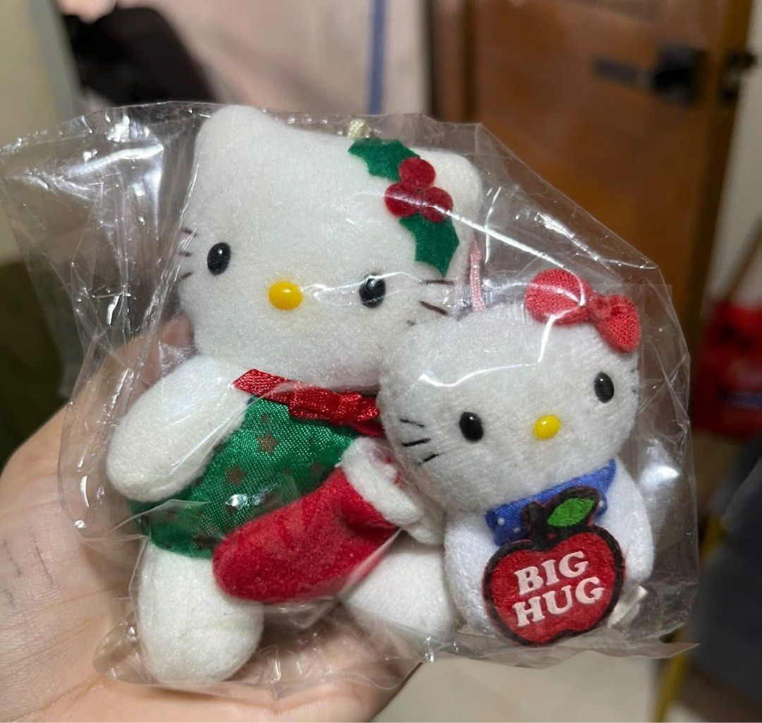 Hello Kitty Christmas and Big Hug Plush Keychain Set (Category: Plushies & Soft Toys) located in Manila. Submitted by janetecson05 (Listing ID 1467002894, Image 1). Description: - Set of 2 adorable Kitty plush keychains - Keychain 1: Festive green Christmas outfit with holly and red stocking - Keychain 2: Blue polka dot collar holding a red 'Big Hug' apple patch - Brand new, sealed in original plastic packaging - Perfect for gifts, bag charms, or