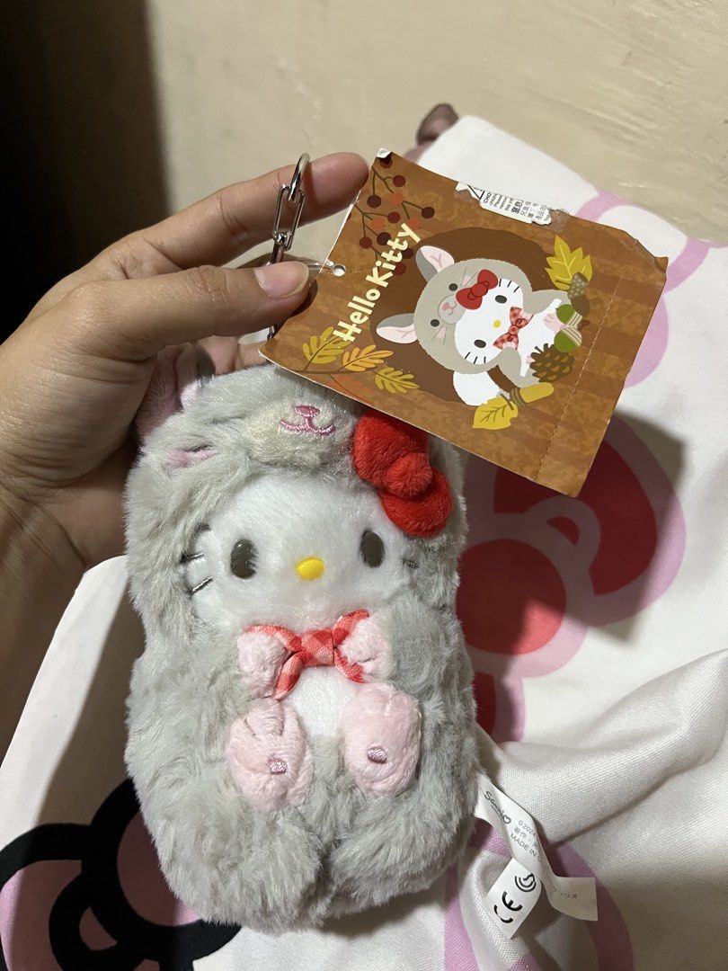 Hello Kitty Grey Animal Costume Plush Keychain (Category: Plushies & Soft Toys) located in Manila. Submitted by janetecson05 (Listing ID 1467060965, Image 1). Description: - Authentic Kitty plush keychain - Features a cozy grey furry animal costume with cute pink paws - Iconic red bow and white body visible - Includes attached metal keyring for easy hanging - Comes with original paper tag still attached - Perfect for bags, keys, or as a gift for 