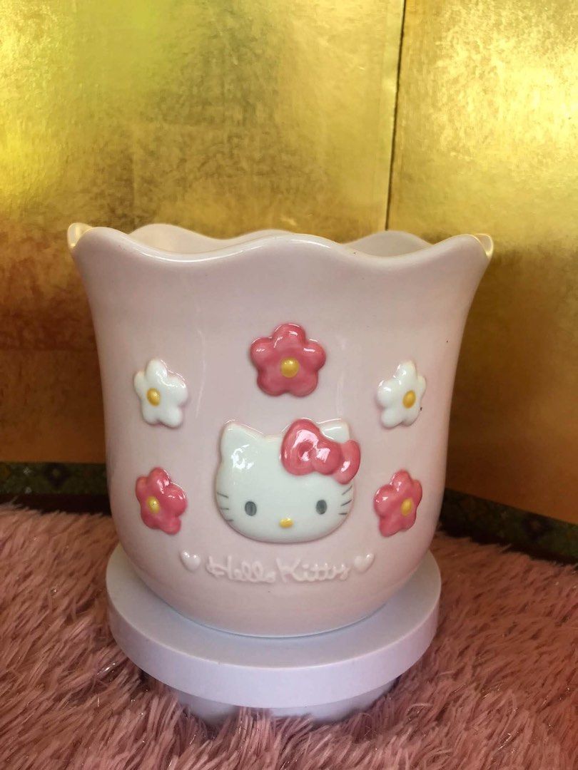 Hello Kitty Pink Ceramic Pot Holder Planter (Category: Pots & Planters) located in Manila. Submitted by janetecson05 (Listing ID 1467002299, Image 1). Description: - Authentic Kitty pastel pink ceramic pot - Features a charming scalloped top edge with 3D embossed flowers and Kitty face - Elegant script logo stamped near the bottom - Glossy finish with a heavy, durable, and sturdy build - Versatile use: perfect for small plants, makeup brushes, or