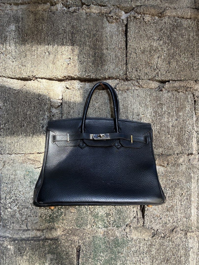 Hermes Birkin Black Leather Handbag (Category: Luxury Bags & Wallets) located in Manila. Submitted by assortedgoodsv3 (Listing ID 1467165961, Image 1). Description: - Material: Premium black textured leather - Hardware: Elegant gold-tone with Hermes Paris engraving - Handles: Two sturdy top handles for easy carrying - Closure: Signature strap and lock closure system - Base: Structured with protective feet for added durability.