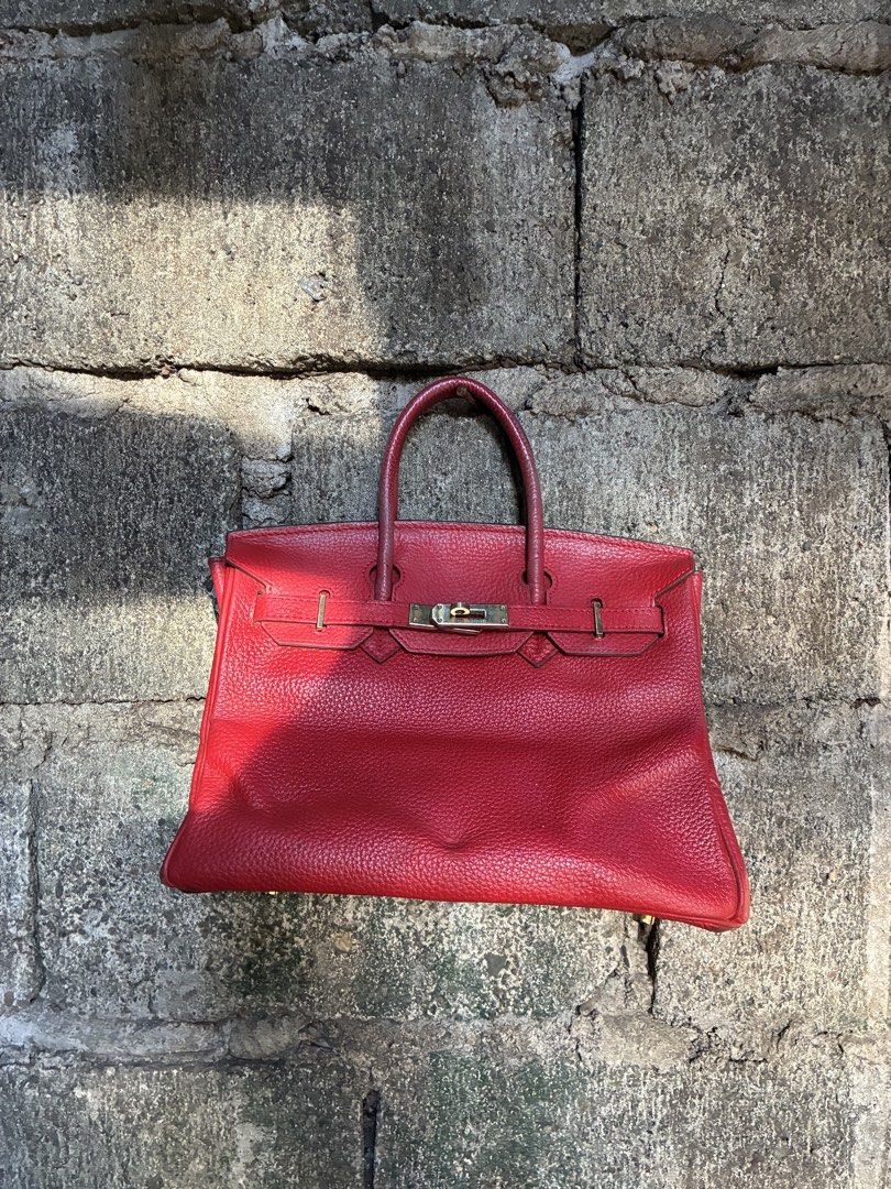 Hermes Birkin Red Leather Handbag (Category: Luxury Bags & Wallets) located in Manila. Submitted by assortedgoodsv3 (Listing ID 1467165976, Image 1). Description: - Brand: Hermes Birkin - Material: Bright red textured leather - Hardware: Gold-tone with 'Hermes-Paris' engraved closure plate - Design: Dual top handles, front strap closure with turn-lock mechanism, structured silhouette, and protective base feet - Condition: Classic high-end piece w