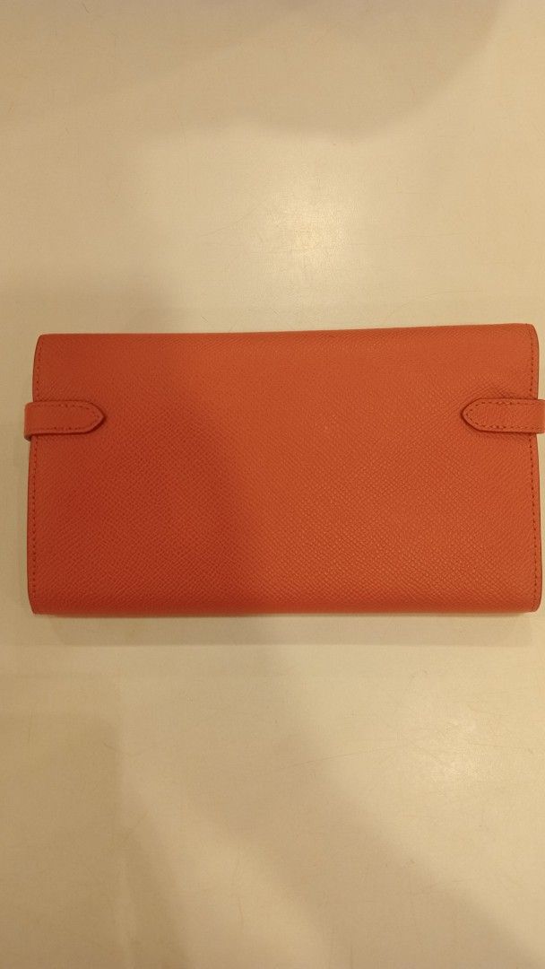 Hermes Kelly Wallet Orange Epsom Silver Hardware (Category: Luxury Bags & Wallets) located in Cagayan de Oro. Submitted by zoe-ini (Listing ID 1467036255, Image 2). Description: - Material: Durable orange textured leather - Hardware: Silver-tone with classic front turn-lock closure - Interior: Multiple card slots, compartment dividers, and a central zippered coin pouch - Condition: Clean structure and well-maintained - Style: Chic, timeless Kelly