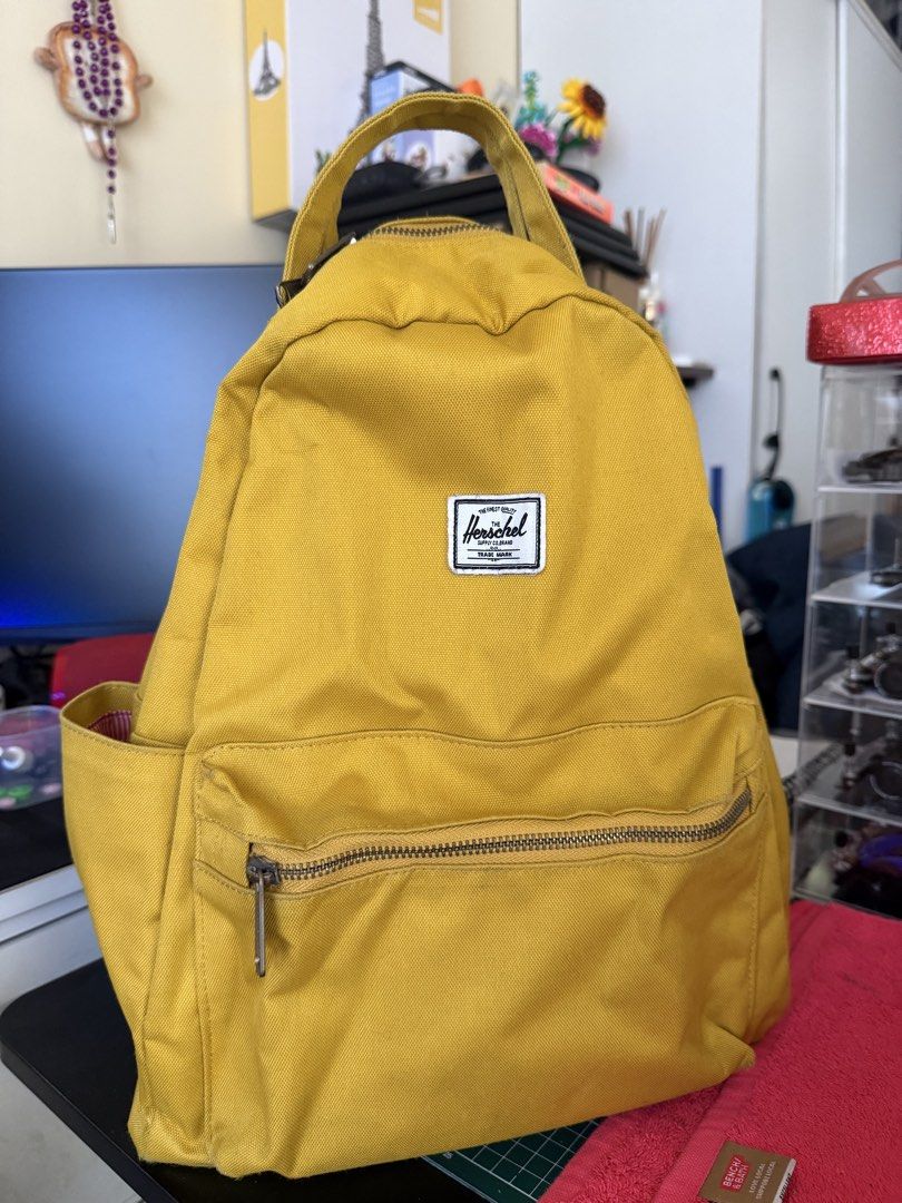 Herschel Yellow Backpack (Category: Backpacks) located in Makati City. Submitted by miguelcm (Listing ID 1466994091, Image 2). Description: - Authentic Herschel backpack in a vibrant bright yellow canvas - Iconic white woven logo patch on the front - Exterior features a front zippered pocket and two side slip pockets for water bottles - Comfortable top carry handle and adjustable shoulder straps - Signature red and white striped fabric lining wit