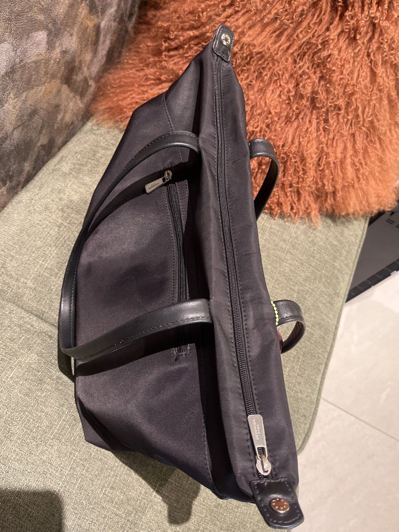 Hexagona Paris Black Nylon Tote (Category: Tote Bags) located in Pasig City. Submitted by jnzmrq1003 (Listing ID 1467047884, Image 2). Description: - Brand: Hexagona Paris - Material: Durable black nylon with black leather double shoulder straps - Storage: Top zip closure, front flap pocket with embossed branding, and back zipper access - Extras: Includes a stylish yellow and maroon capsule-shaped charm - Condition: spilled superglue inside one o