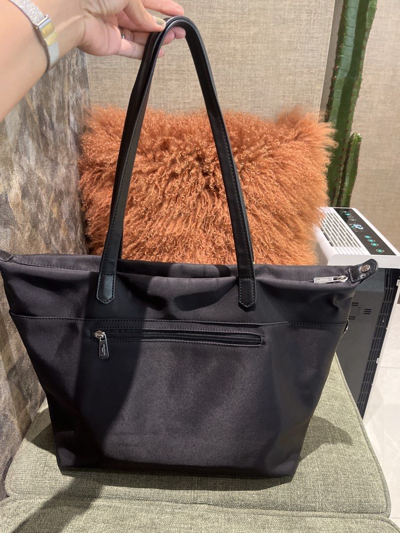Hexagona Paris Black Nylon Tote (Category: Tote Bags) located in Pasig City. Submitted by jnzmrq1003 (Listing ID 1467047884, Image 3). Description: - Brand: Hexagona Paris - Material: Durable black nylon with black leather double shoulder straps - Storage: Top zip closure, front flap pocket with embossed branding, and back zipper access - Extras: Includes a stylish yellow and maroon capsule-shaped charm - Condition: spilled superglue inside one o
