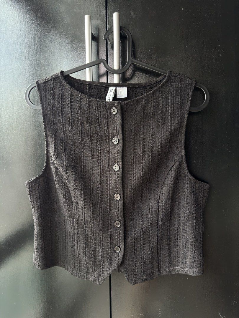 H&M Divided Black Textured Button-Front Vest Size M (Category: Sleeveless) located in Makati City. Submitted by rj_0912 (Listing ID 1467164640, Image 1). Description: - Brand/Model: H&M Divided Black Button-Front Vest - Size: Medium (true to size) - Material: Textured fabric - Design: Scoop neckline, sleeveless, dark front buttons, tailored fit, V-shaped front hem - Condition: Great basic piece for layering or solo wear.