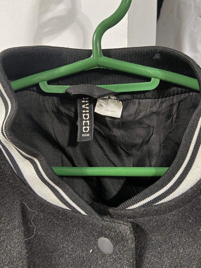H&M Divided Black Varsity Jacket (Category: Coats, Jackets and Outerwear) located in Manila. Submitted by koolash (Listing ID 1467165636, Image 2). Description: - Brand: H&M Divided - Style: Classic black varsity jacket - Size: Large (fits true to standard sizing) - Material: Contrast faux leather sleeves - Details: Snap-button front closure, side pockets, and striped ribbed collar, cuffs, and hem - Condition: Great casual staple.
