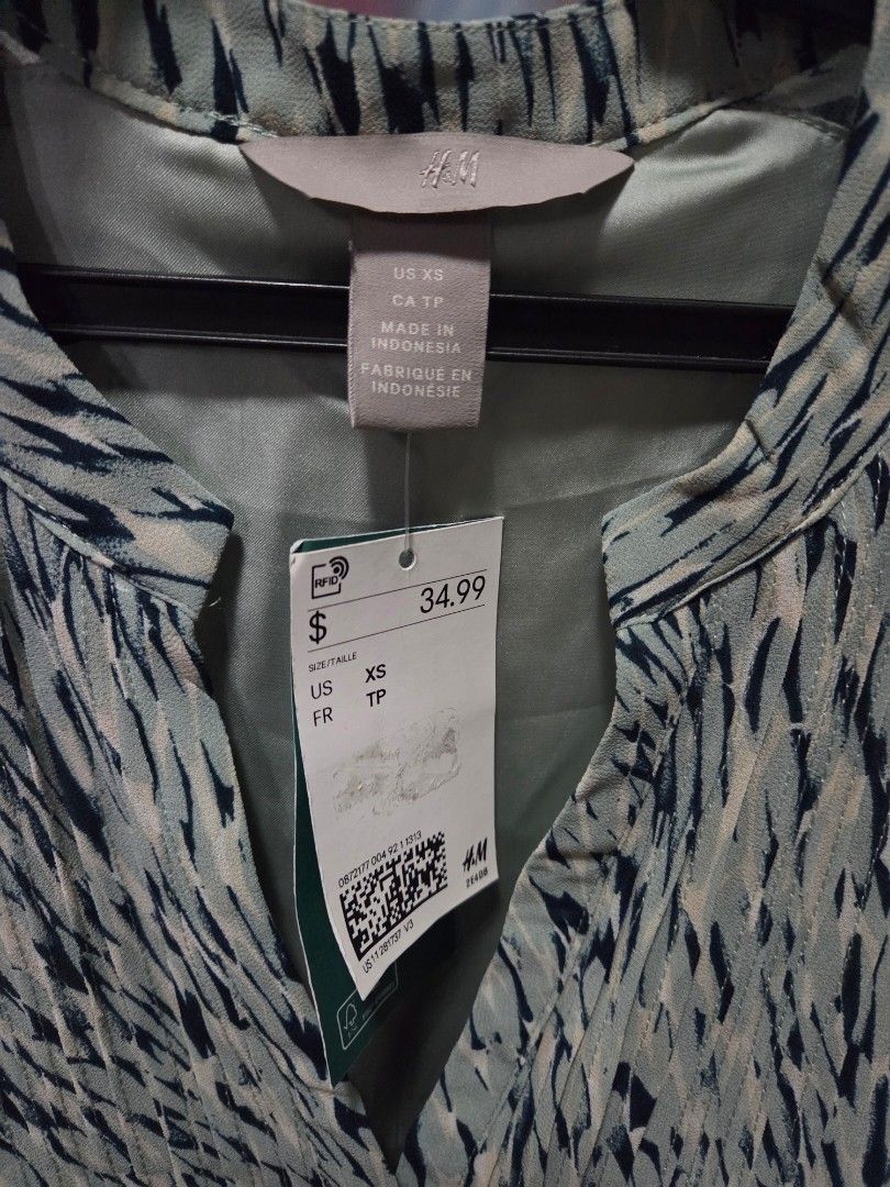 H&M Patterned V-Neck Dress XS (Category: Dresses) located in Pasig City. Submitted by ldcayas (Listing ID 1467048701, Image 3). Description: - Brand: H&M - Color/Pattern: Green and dark blue pattern - Size: US XS (Made in Indonesia) - Condition: Brand new with original retail tags attached - Features: Short sleeves, flattering V-neckline, adjustable tie waist detail in the back - Lining: Fully lined interior for comfort and quality Mode of Paymen