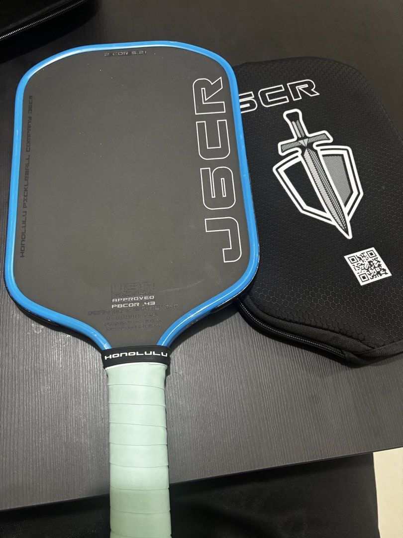 Honolulu J6CR Paddle standard grit (Category: Racket and Ball Sports) located in Manila. Submitted by meddsalim (Listing ID 1467110798, Image 1). Description: With edge tape - Brand: Honolulu Pickleball Company J6CR - Colorway: Black face with blue trim - Specifications: USA Pickleball approved, PBCOR.43, designed and engineered in Hawaii USA - Upgrades: Wrapped with stylish light mint green grip tape - Inclusions: Comes with original J6CR protec