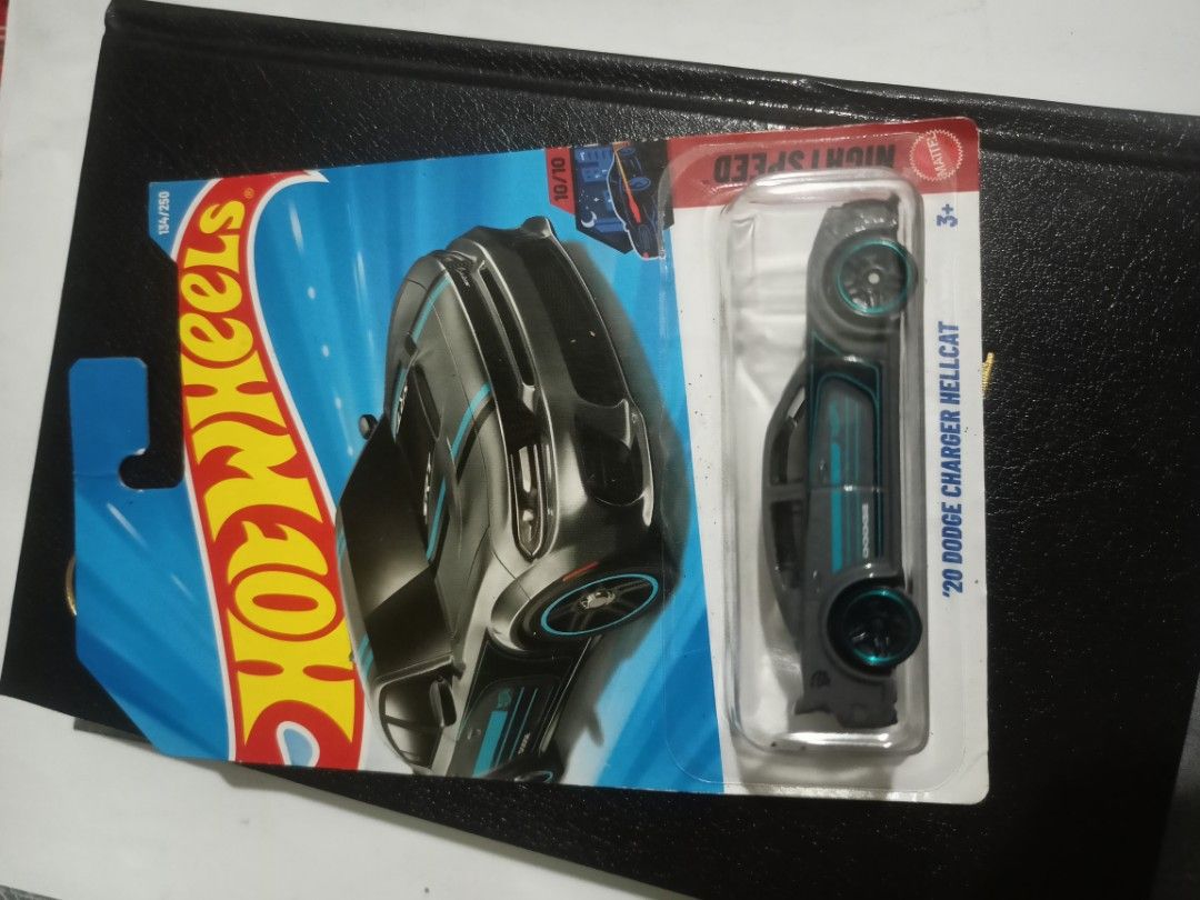 Hot Wheels '20 Dodge Charger Hellcat Night Speed (Category: Vehicle & Diecast Models) located in Manila. Submitted by junjunortega09 (Listing ID 1467013139, Image 1). Description: - Model: '20 Dodge Charger Hellcat - Series: Night Speed (134/250) - Color/Design: Dark grey with blue and black hood/side stripes - Wheels: Matching blue rims - Condition: Brand new, still sealed in original packaging.