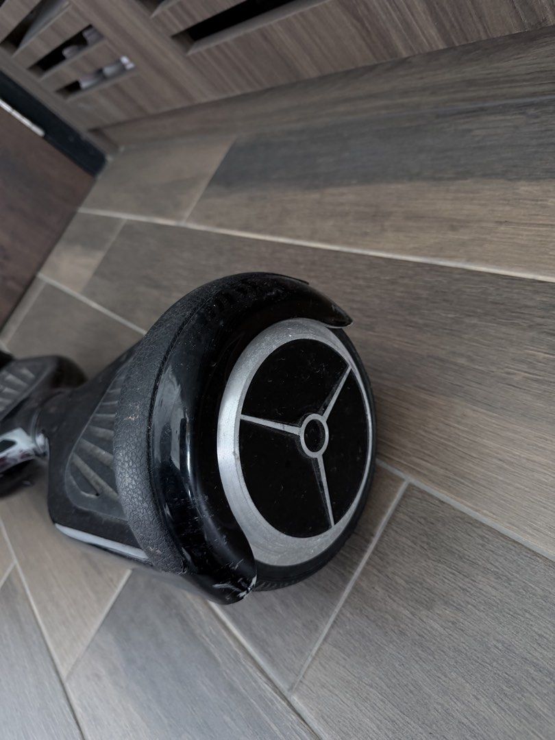 Hoverboard (Category: Hoverboards) located in Singapore. Submitted by chewylee (Listing ID 1467013189, Image 3). Description: - comes with a carry case and charger - Features: Rubber foot pads, solid wheels, standard charging port, and rear power button - Condition: Fully functional with visible scuffs and scratches on the body; normal wear on wheels and hubcaps - Deal: Self-collection preferred in woodlands area.