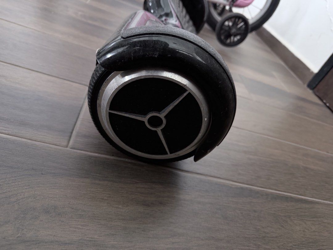 Hoverboard (Category: Hoverboards) located in Singapore. Submitted by chewylee (Listing ID 1467013189, Image 5). Description: - comes with a carry case and charger - Features: Rubber foot pads, solid wheels, standard charging port, and rear power button - Condition: Fully functional with visible scuffs and scratches on the body; normal wear on wheels and hubcaps - Deal: Self-collection preferred in woodlands area.